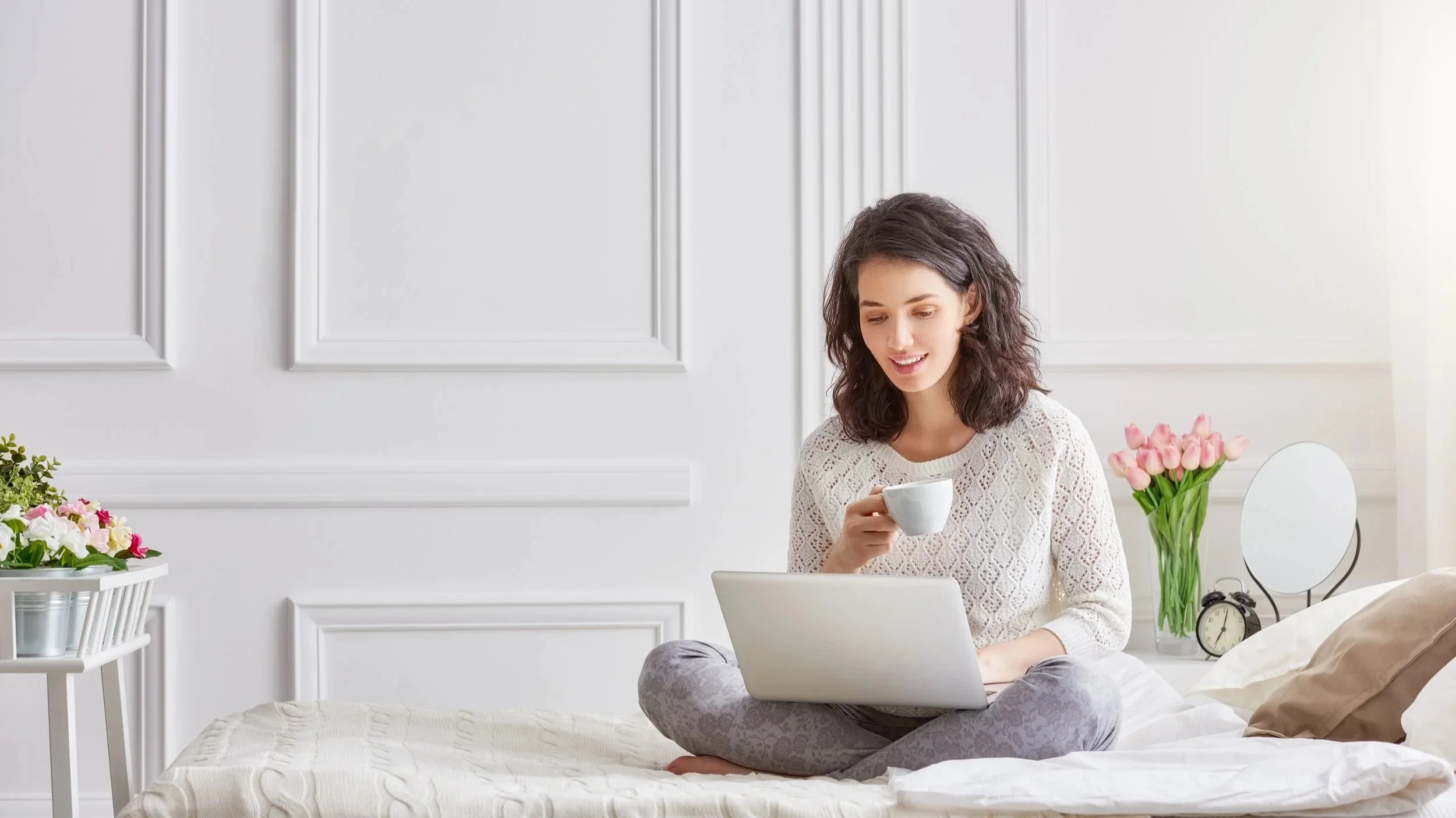 Relaxed young woman working on her laptop at home — enjoying peace of mind with GoodMaids professional household help.