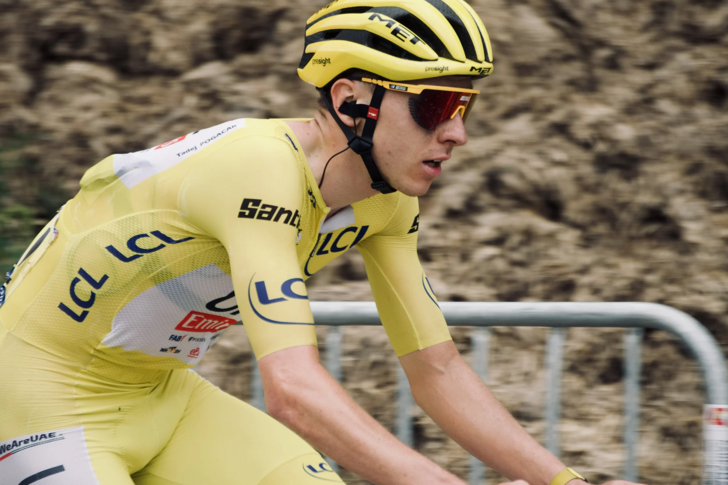 Un cycliste en maillot jaune et casque jaune en pleine course.