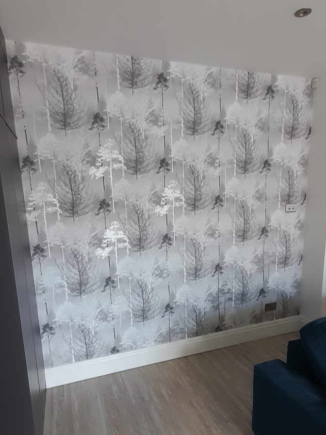 A woodland-themed wallpaper was applied to create a calm, contemporary feature wall. Pattern matching at the seams ensured a seamless, professional finish.