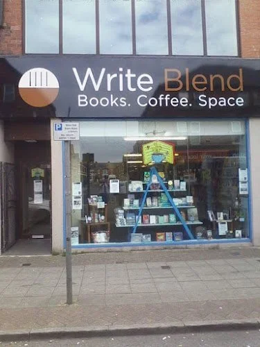 Storefront of Write Blend, a bookstore and coffee shop, featuring large glass windows and an illuminated sign with the store's name.