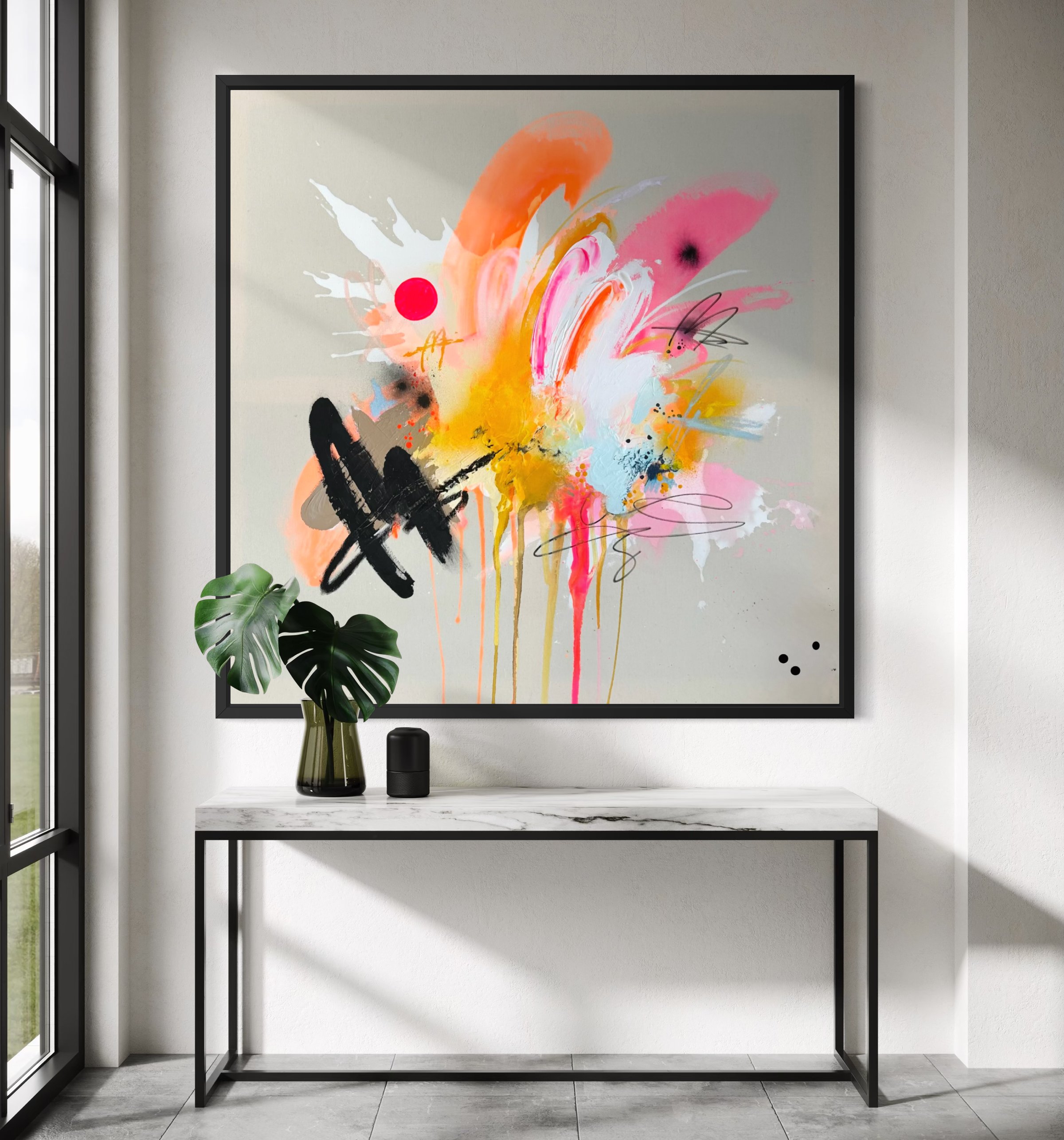 Ein moderner Eingangsbereich mit einer abstrakten, bunten Wandkunst hinter einer schwarzen Metallkonsole. Die Wandkunst besteht aus lebhaften Farben wie Pink, Orange, Gelb und Schwarz in Form von abstrakten Pinselstrichen und Spritzern. Ein grüner Pflanzenstrauß in einer dunklen Vase steht auf der Konsole.