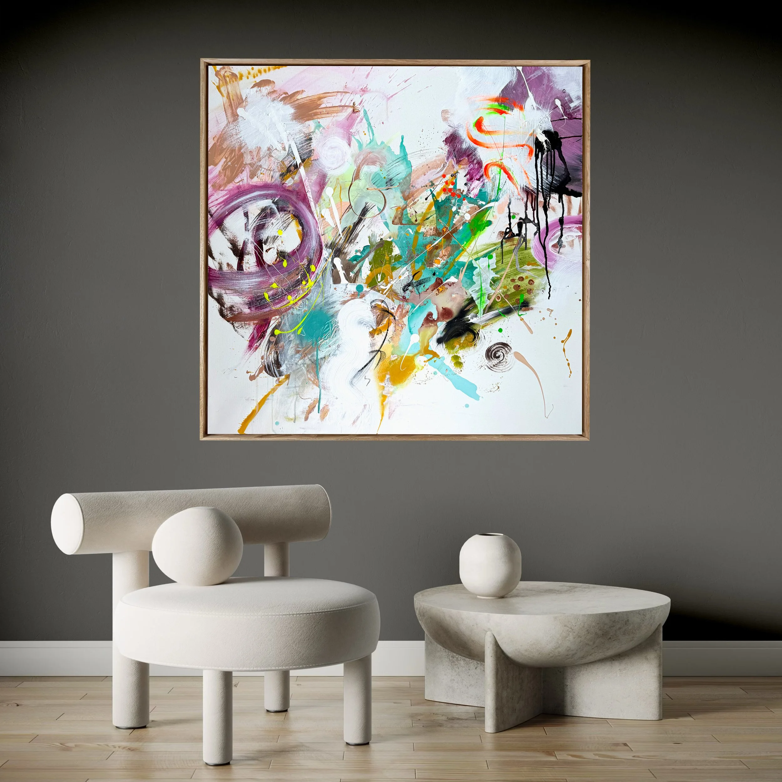 Modernes Wohnzimmer mit grauer Wand, buntem abstraktem Gemälde an der Wand, weißem Sitzmöbel mit runden Elementen, und einem Steintisch mit einer weißen Vase.