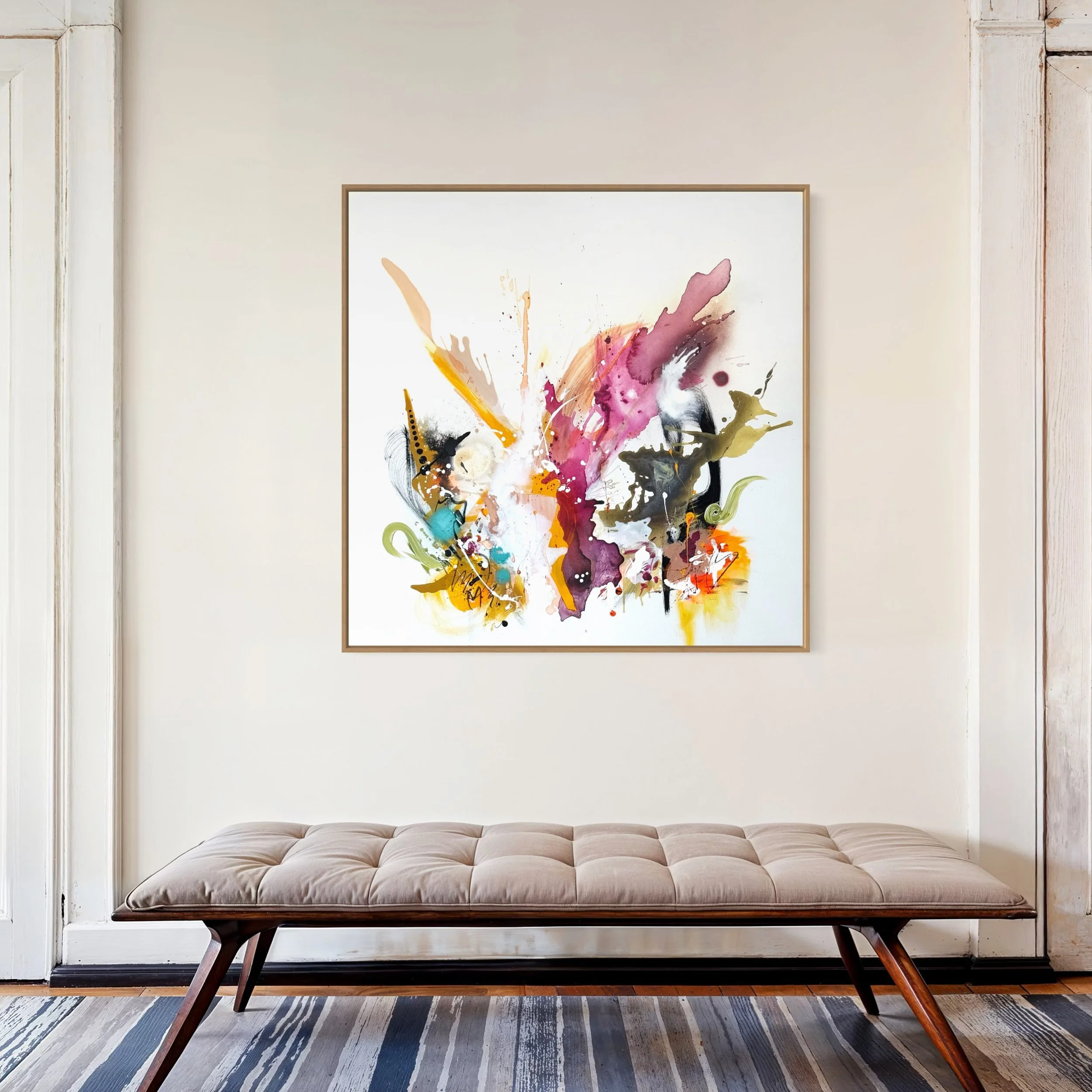 Abstraktes, bunt gemaltes Gemälde mit lebendigen Farben an einer weißen Wand über einem beige Sitzbank