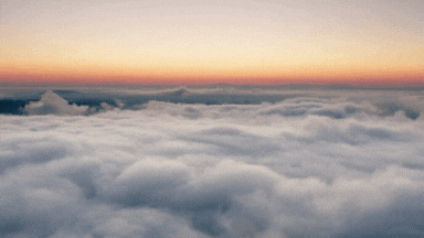 View of a colorful sunset over a sea of clouds.