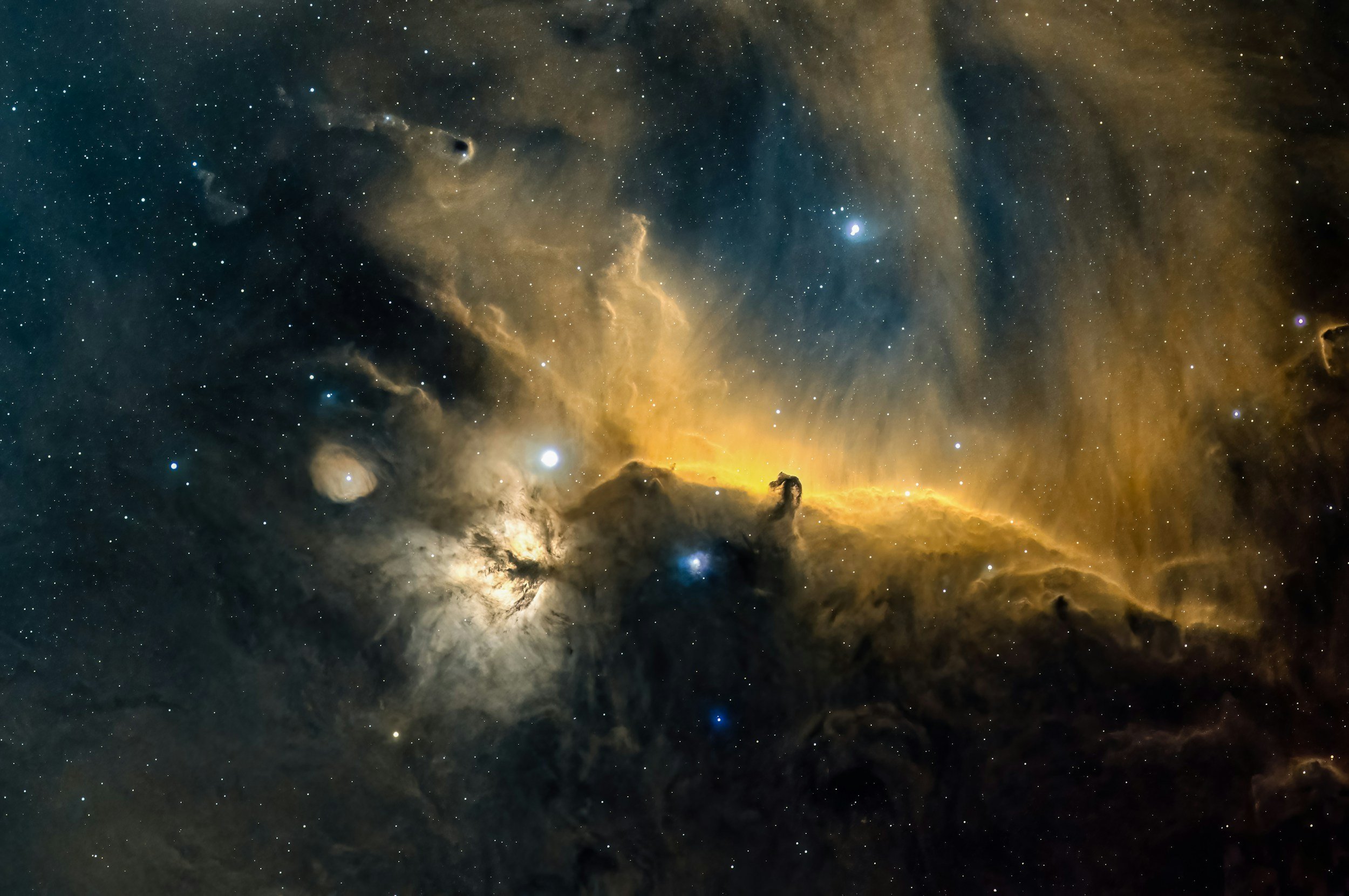 A detailed view of a nebula in space with bright stars, colorful gaseous clouds, and dark dust lanes.