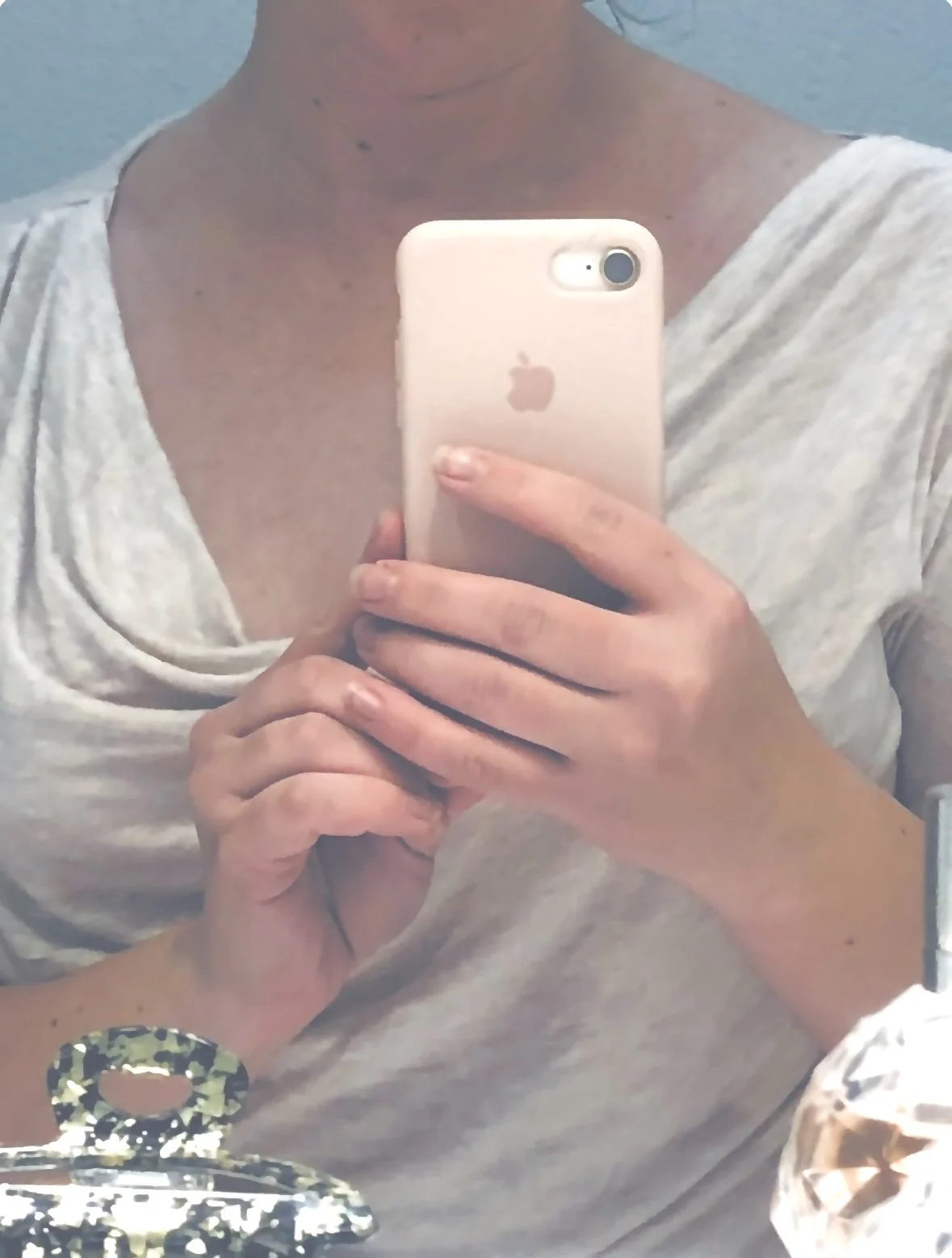 Une personne prenant un selfie avec un iPhone, devant un miroir.