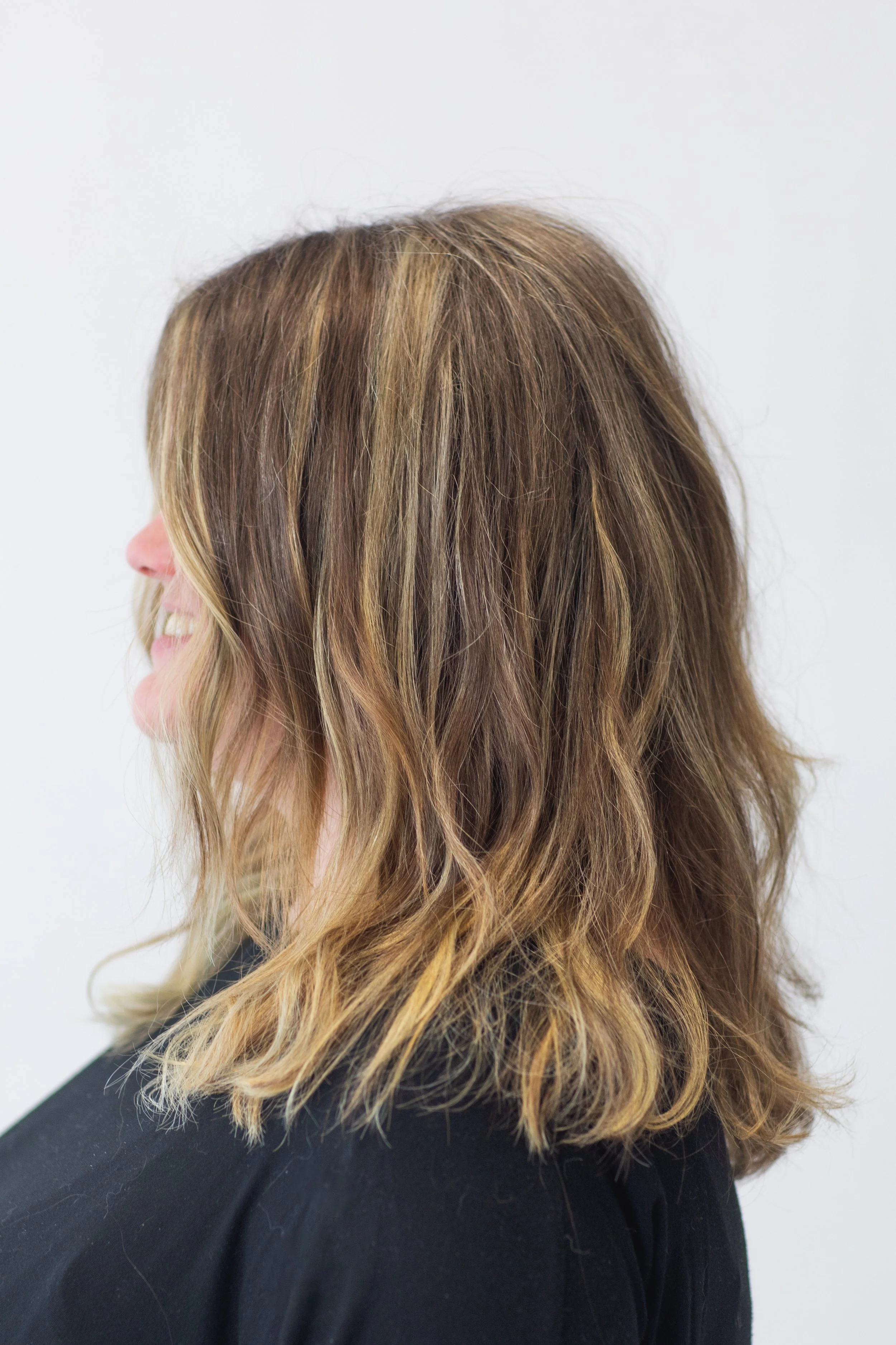 A mid-length cut with dimensional blonde highlights that frame the face and brighten the overall look. Perfect for clients looking for an easy, natural grow-out with plenty of softness and movement. mid-length blonde hair, dimensional highlights Atla