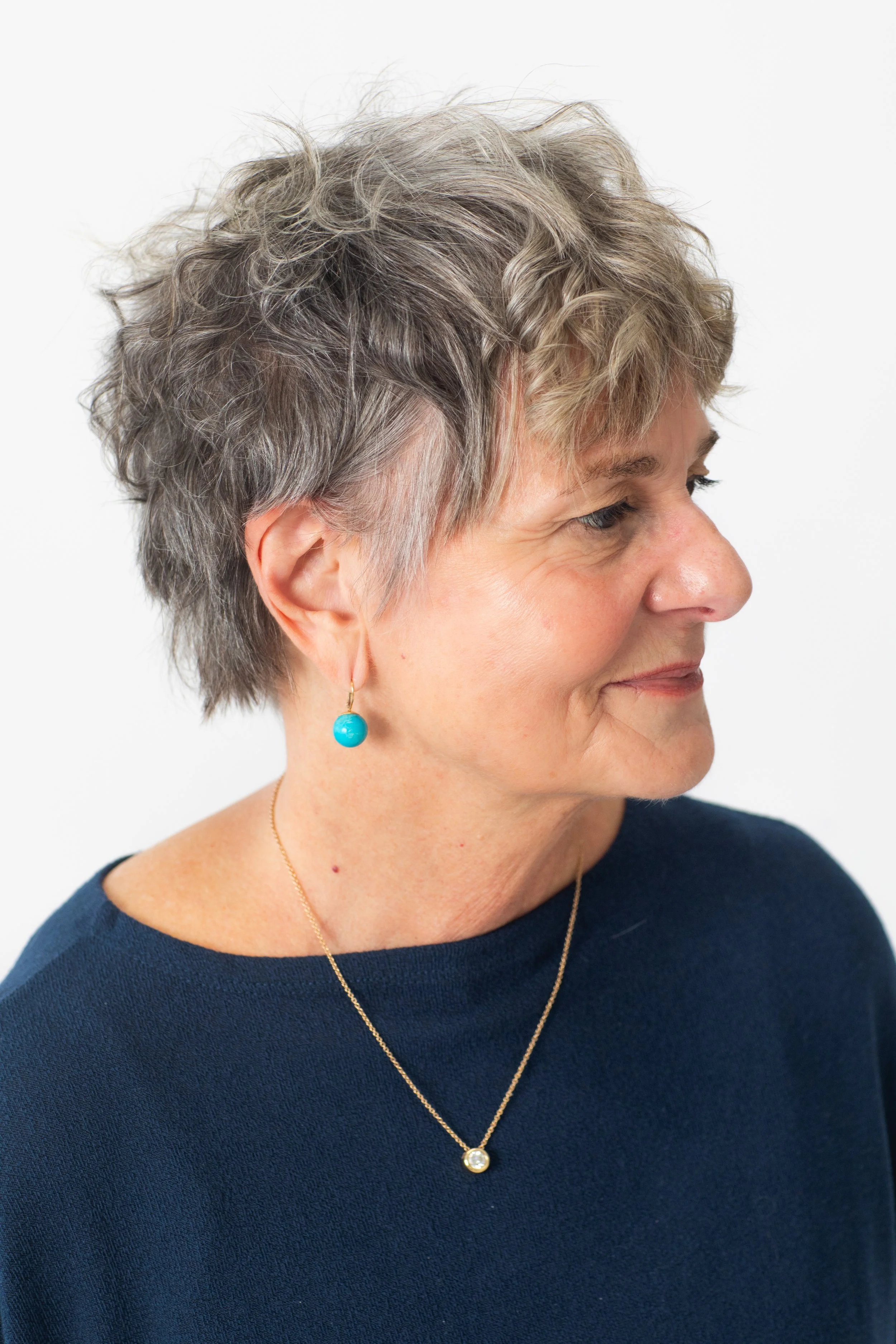 A chic, low-maintenance short cut designed to enhance natural gray texture. Soft layers add movement and volume while embracing the client’s natural color for a modern, effortless finish. gray hair specialist Atlanta, short haircuts for women, natura