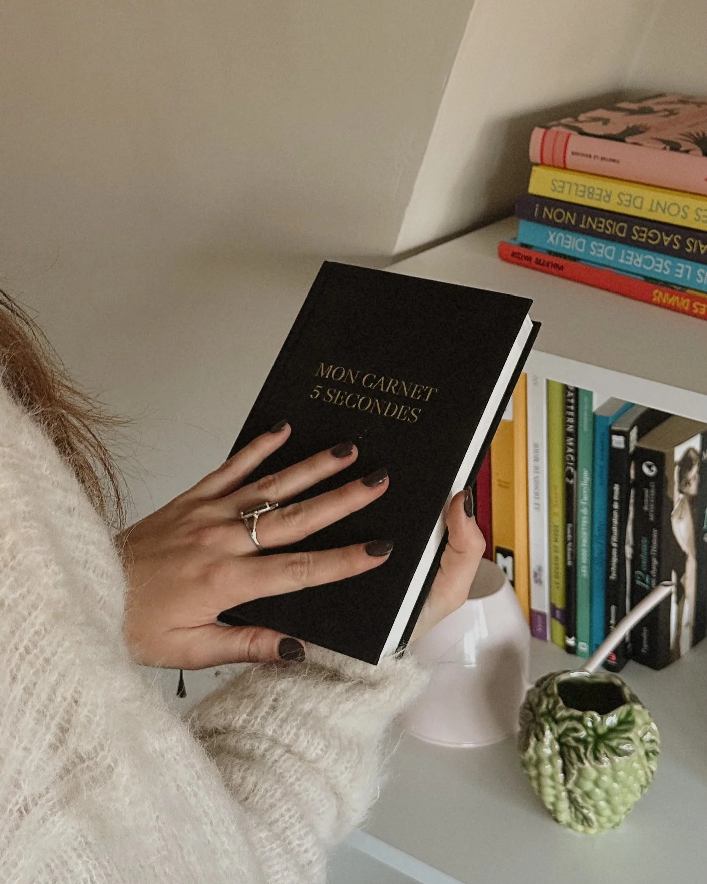 Une femme tenant son carnet 'Mon Carnet 5 Secondes'