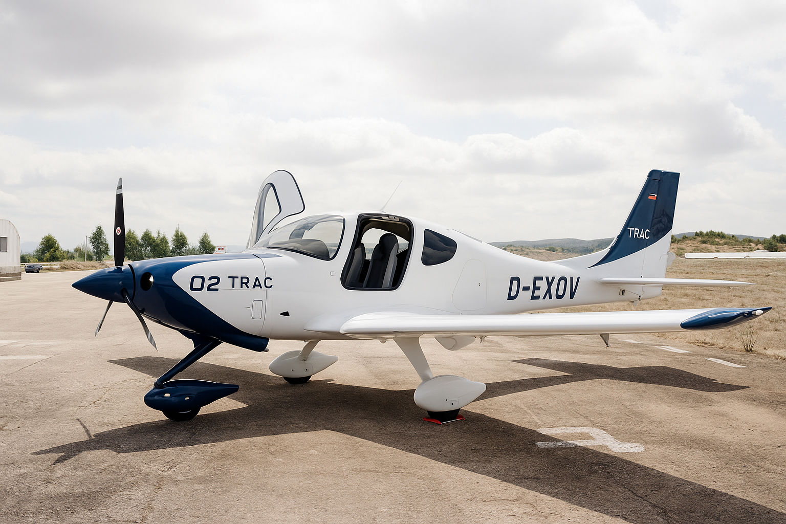 Avião de treino pousado na pista de um aeródromo, com céu nublado ao fundo.