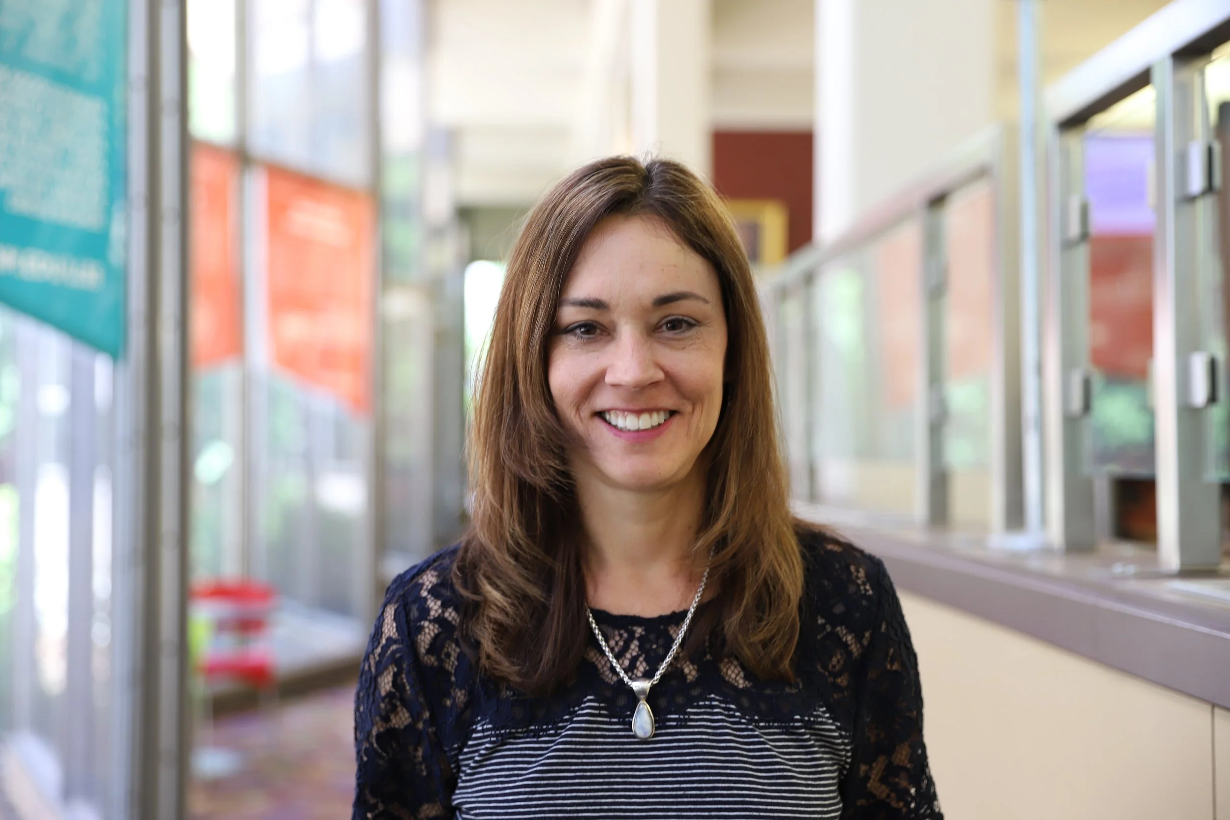 Red neon question mark sign illuminating against a black background.