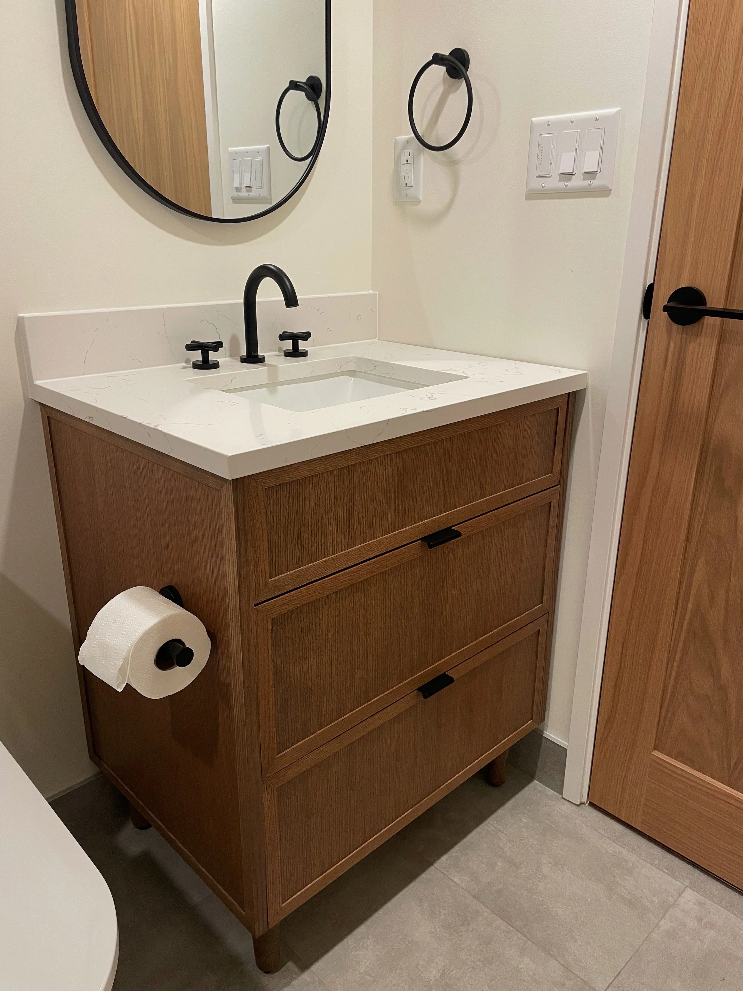 Vancouver bathroom renovation featuring a custom wood vanity and timeless millwork by Herringbone Contracting.