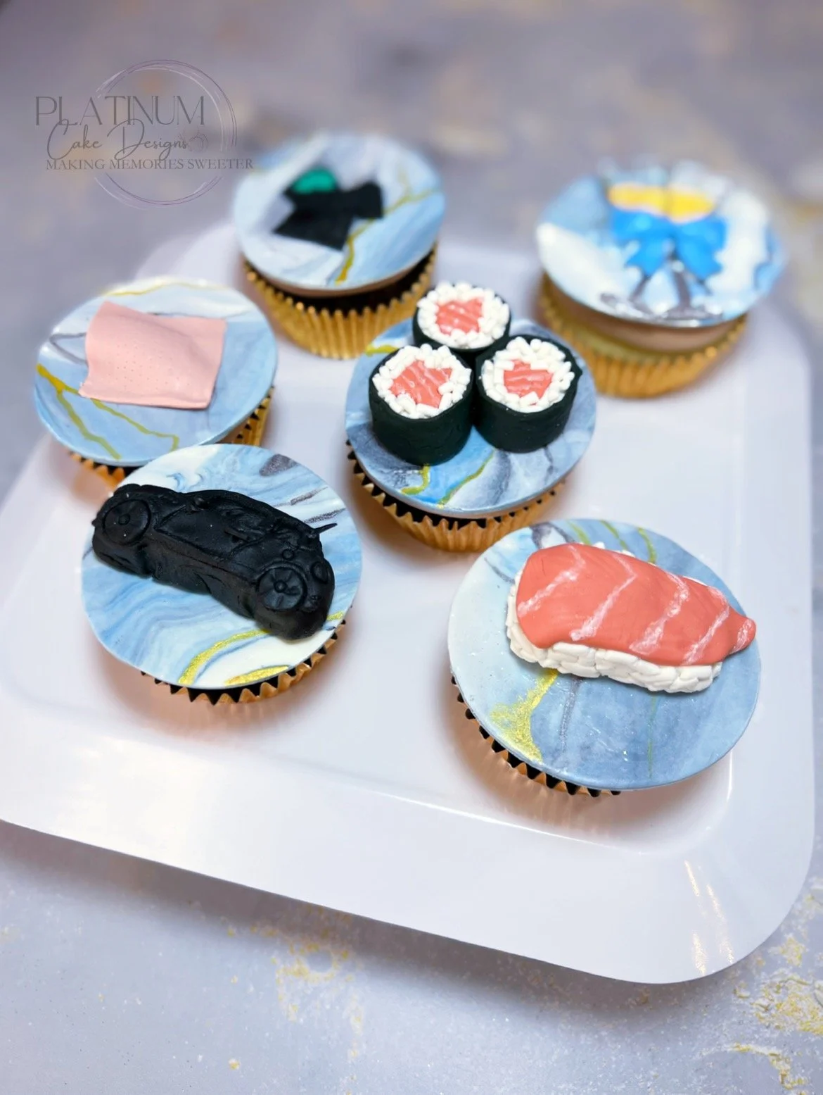 Platinum Cake Designs created these delicious cupcakes for an OB / GYN's office celebrating one of their doctor's birthdays and her favorite things.  We made edible sushi toppers, a mini Cooper, the patch, a scrubs with the company logo, and some cha