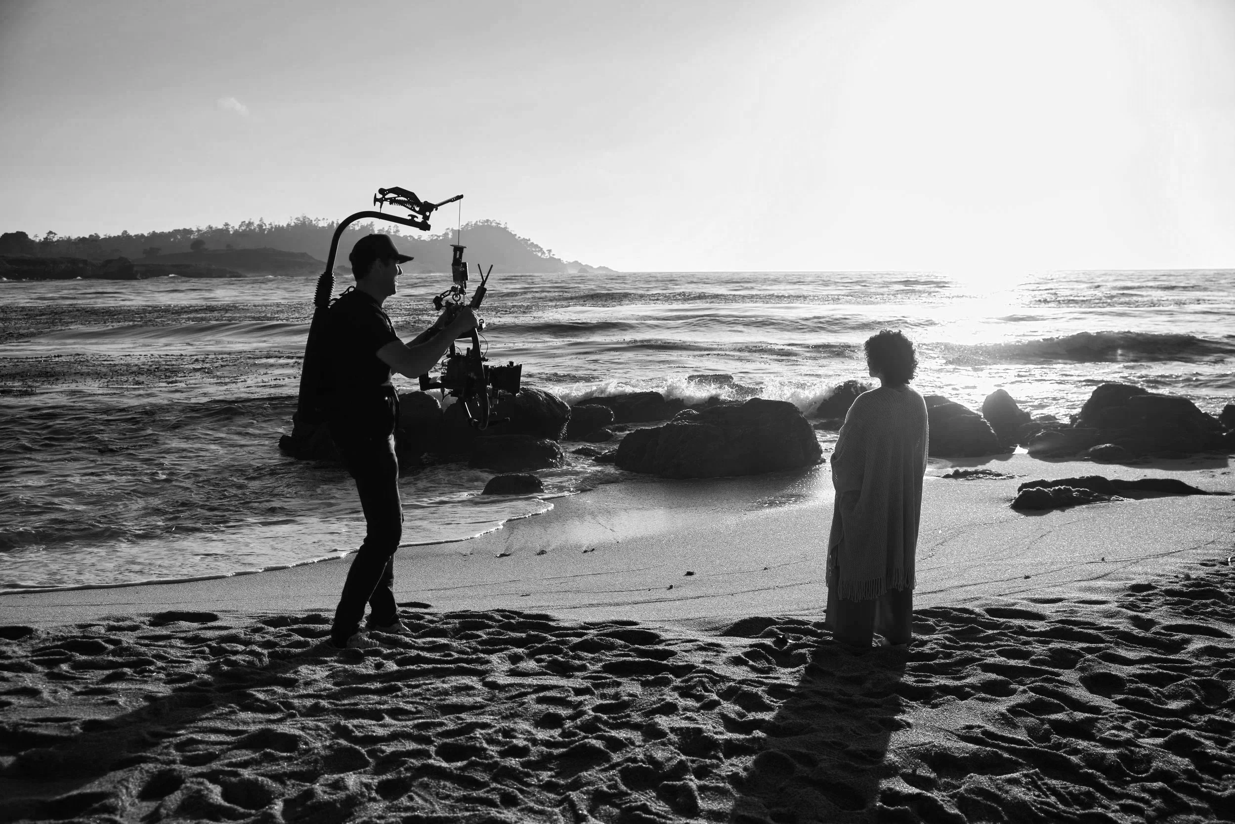 Director of Photography holding a Sony Burano on a Freefly Movi Pro on an Easyrig with SmallHD Monitor and Teradek wireless with a woman on a beach.