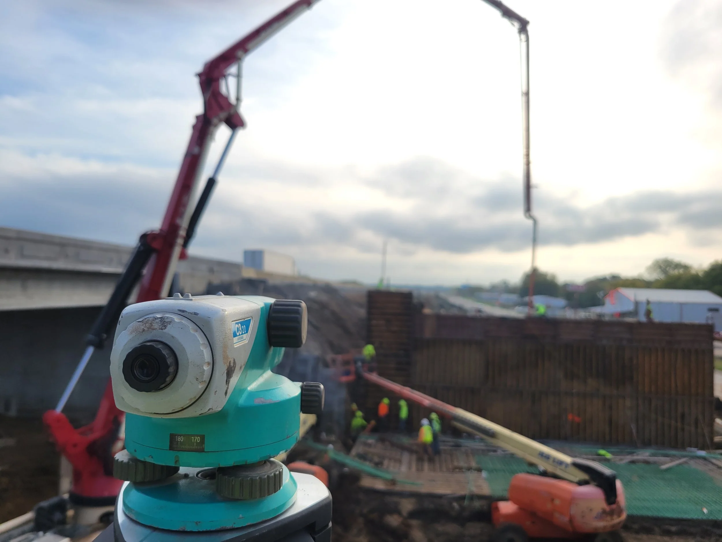 Doing elevation checks as bridge abutment is being poured for beams