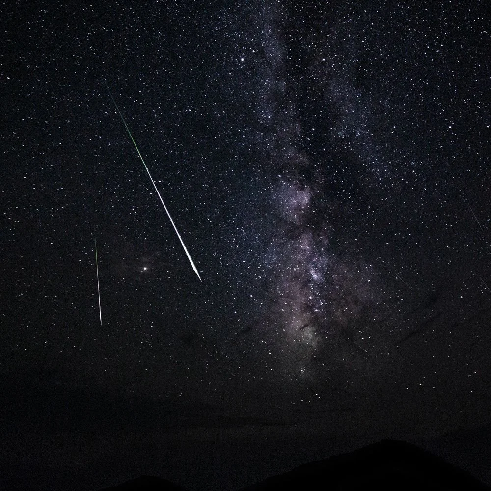 Ciel étoilé et voie lactée avec deux étoiles filantes et leur trainée lumineuse