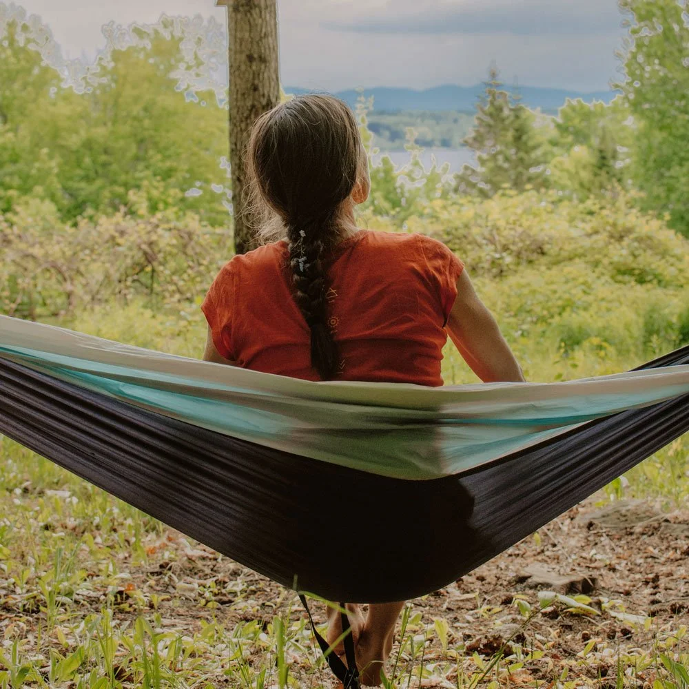 Femme en hamac contemplant le paysage depuis l’Espace Ontara, dans un cadre naturel propice à la reconnexion.