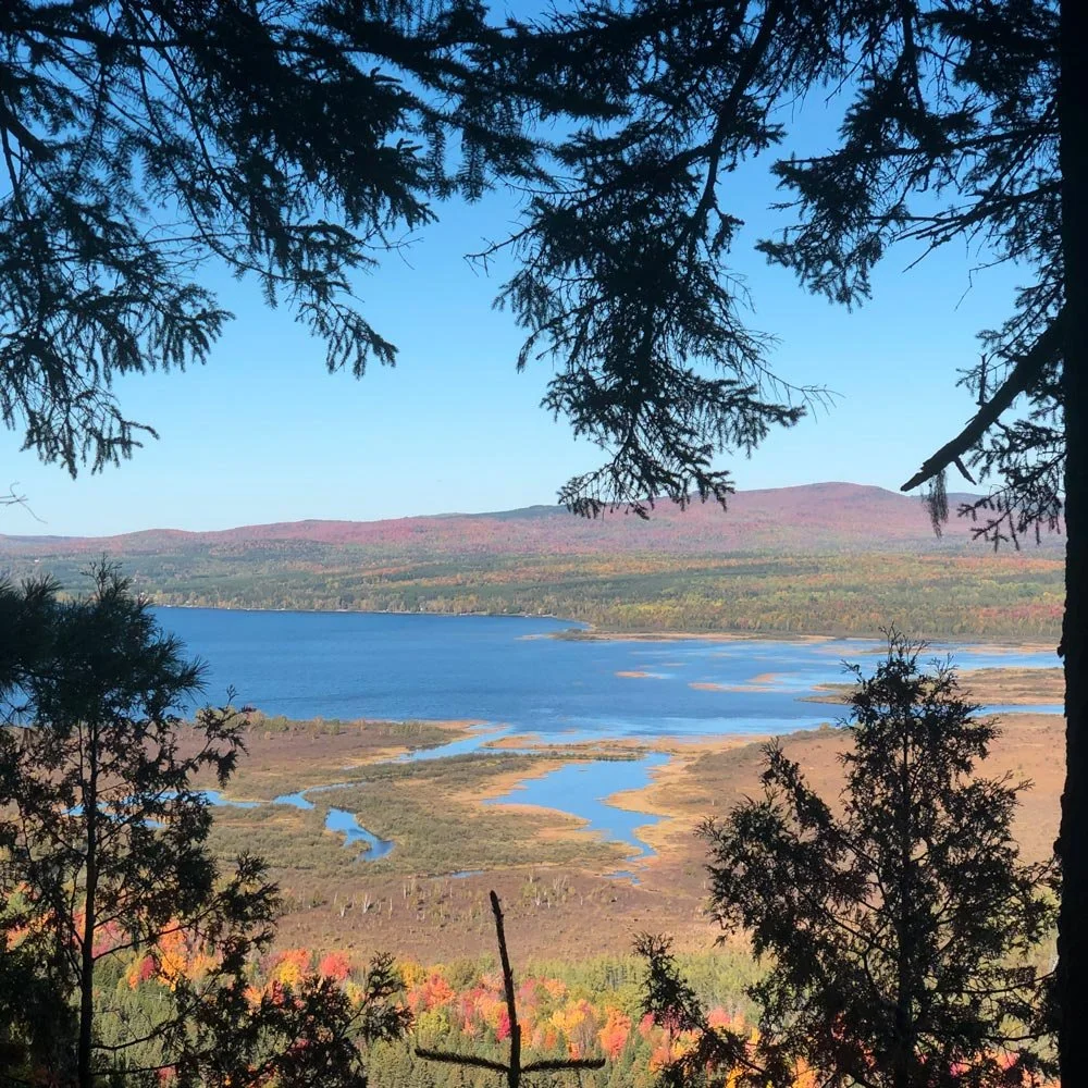 Vue depuis les montagnes sur le lac Mégantic, évoquant la rencontre fondatrice avec le territoire et l’ancrage du projet Aux Cinq Sens.