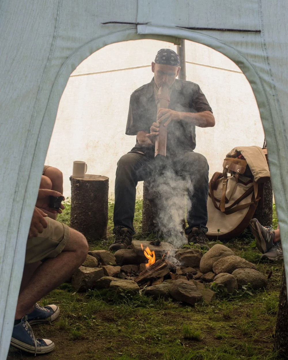 Benoit jouant de la flute au tipi lors d'une activité Aux Cinq Sens.