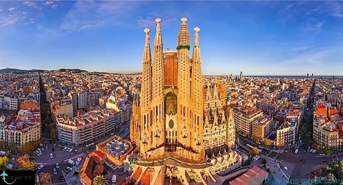 Aerial view of the Sagrada Familia basilica in Barcelona Spain, with surrounding cityscape and clear blue sky.