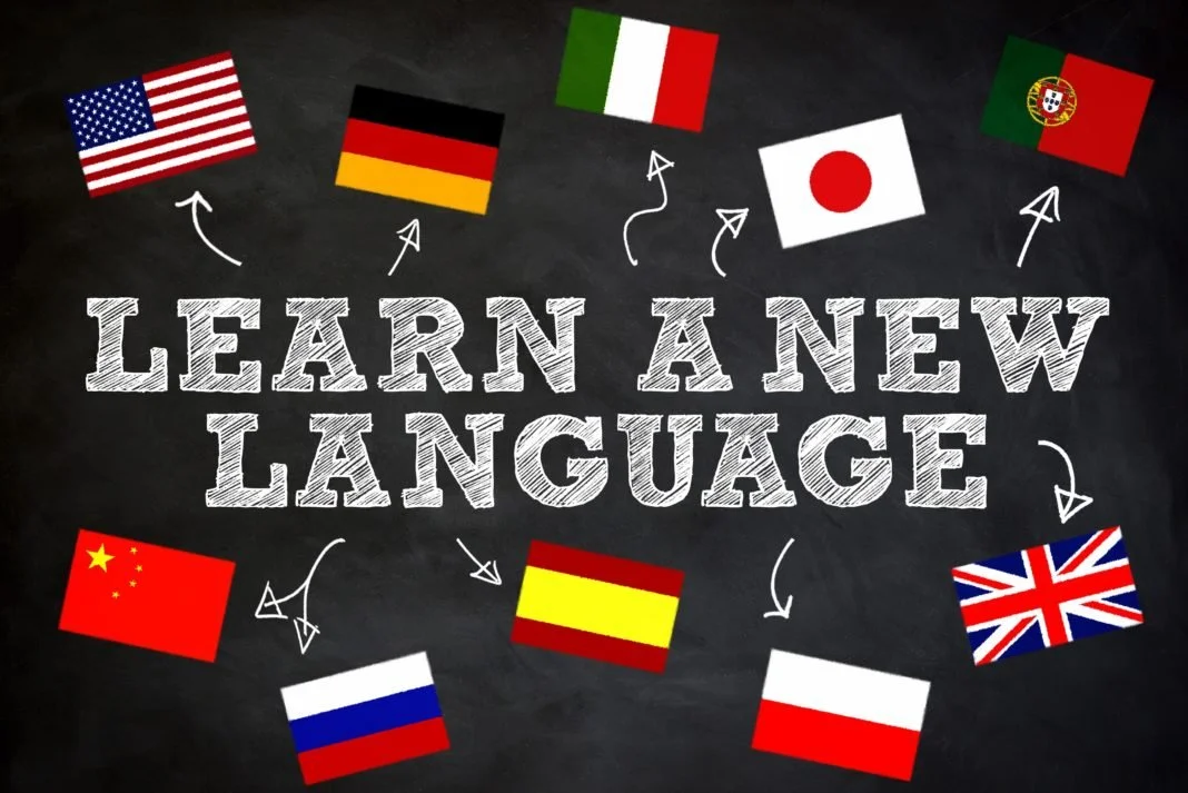 A chalkboard with the text "Learn a New Language" and various international flags surrounding it, including the United States, Germany, Italy, Japan, Portugal, China, Spain, the United Kingdom, and Poland.