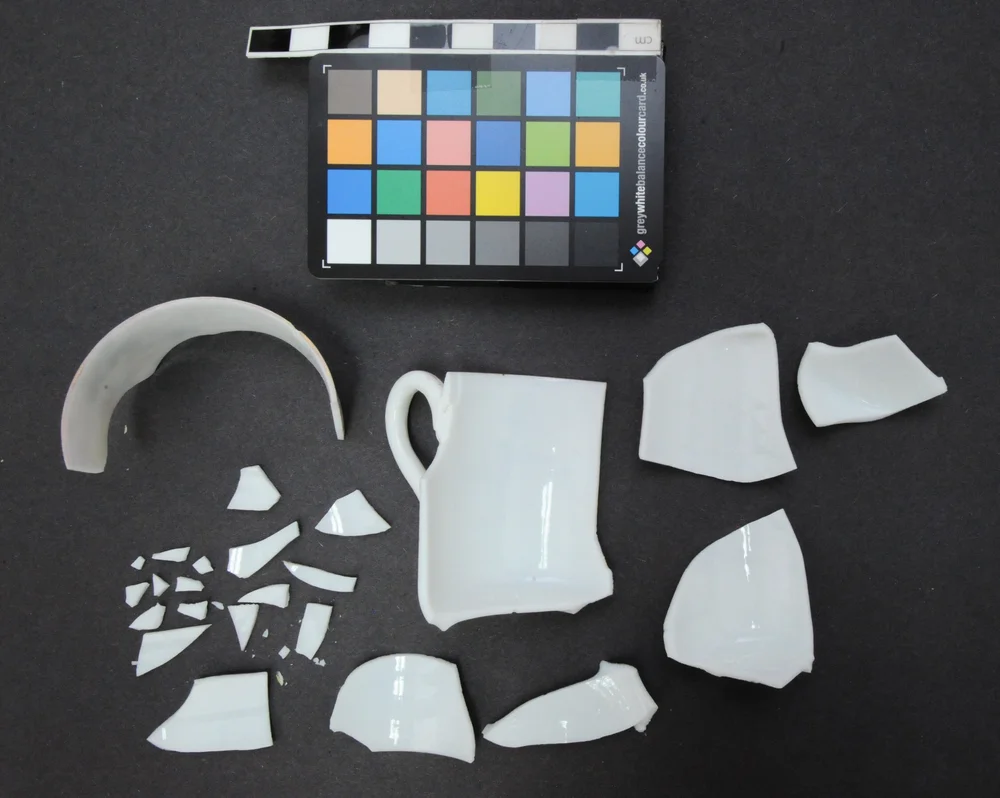 Egg shell porcelain cup with fired glaze repair before treatment.