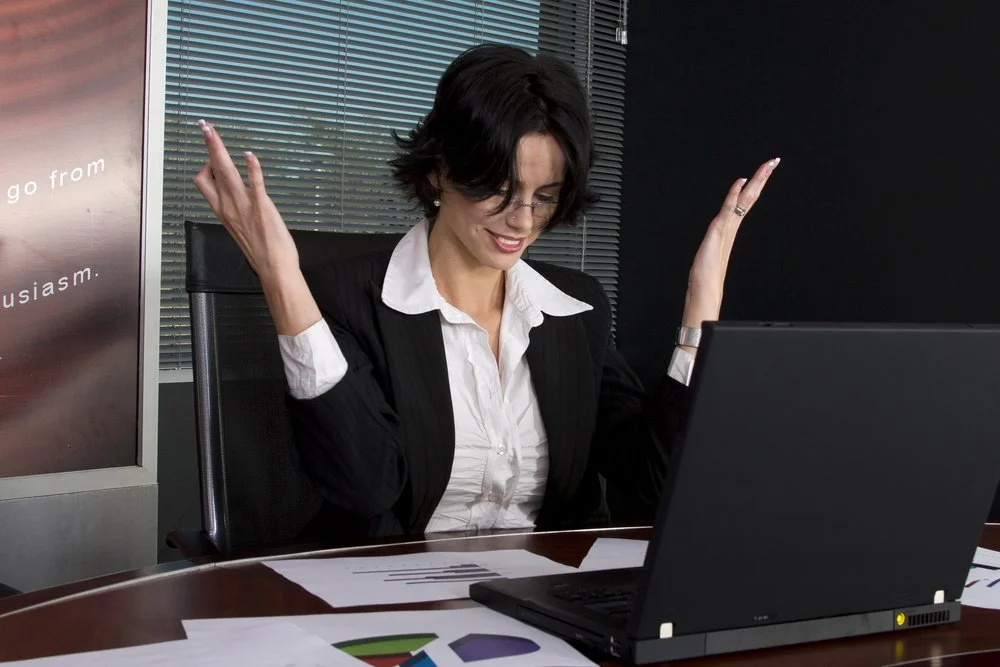 Female office worker gesturing in pain while using her computer