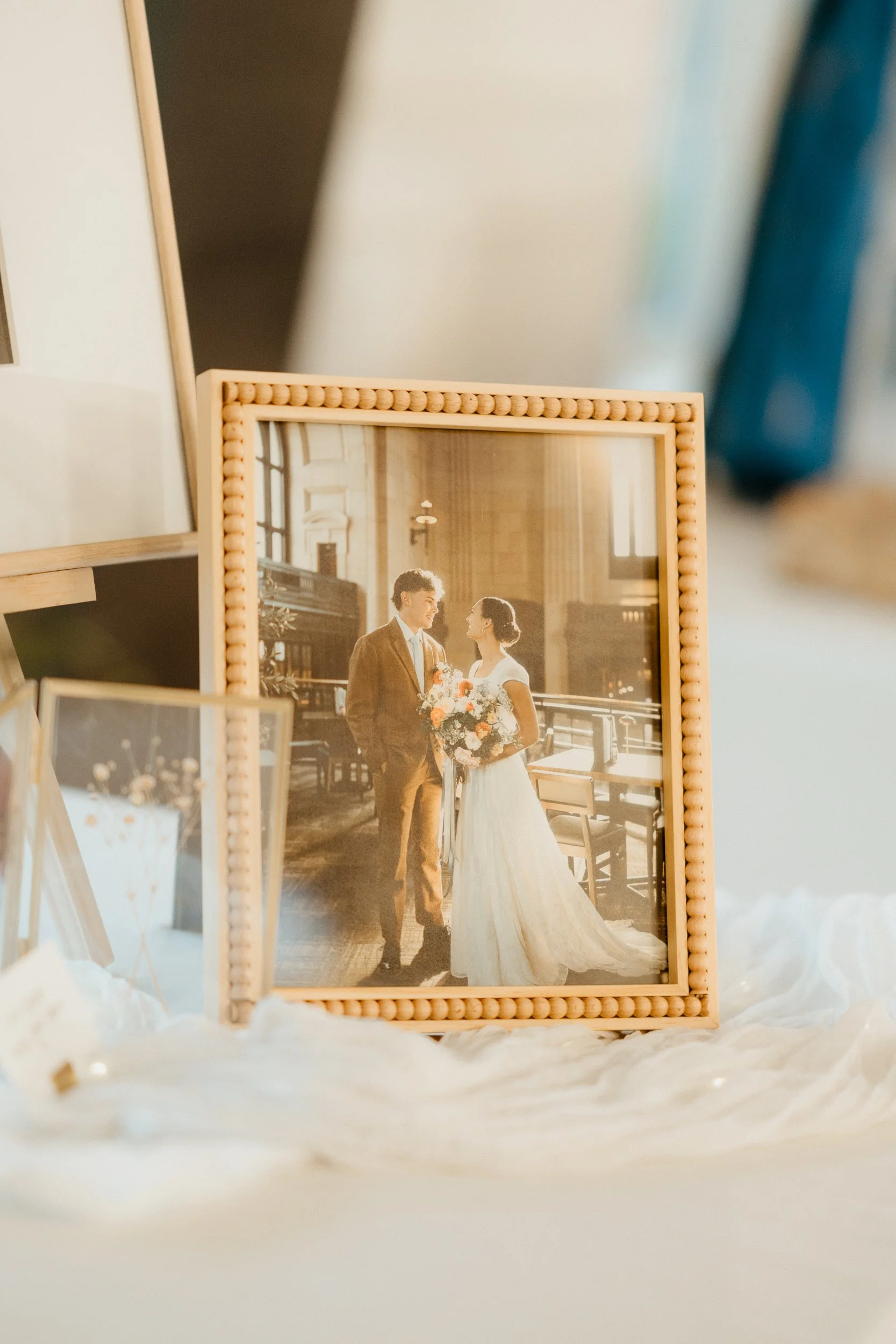 A framed wedding photo of a bride and groom inside a church, displaying warm natural lighting.