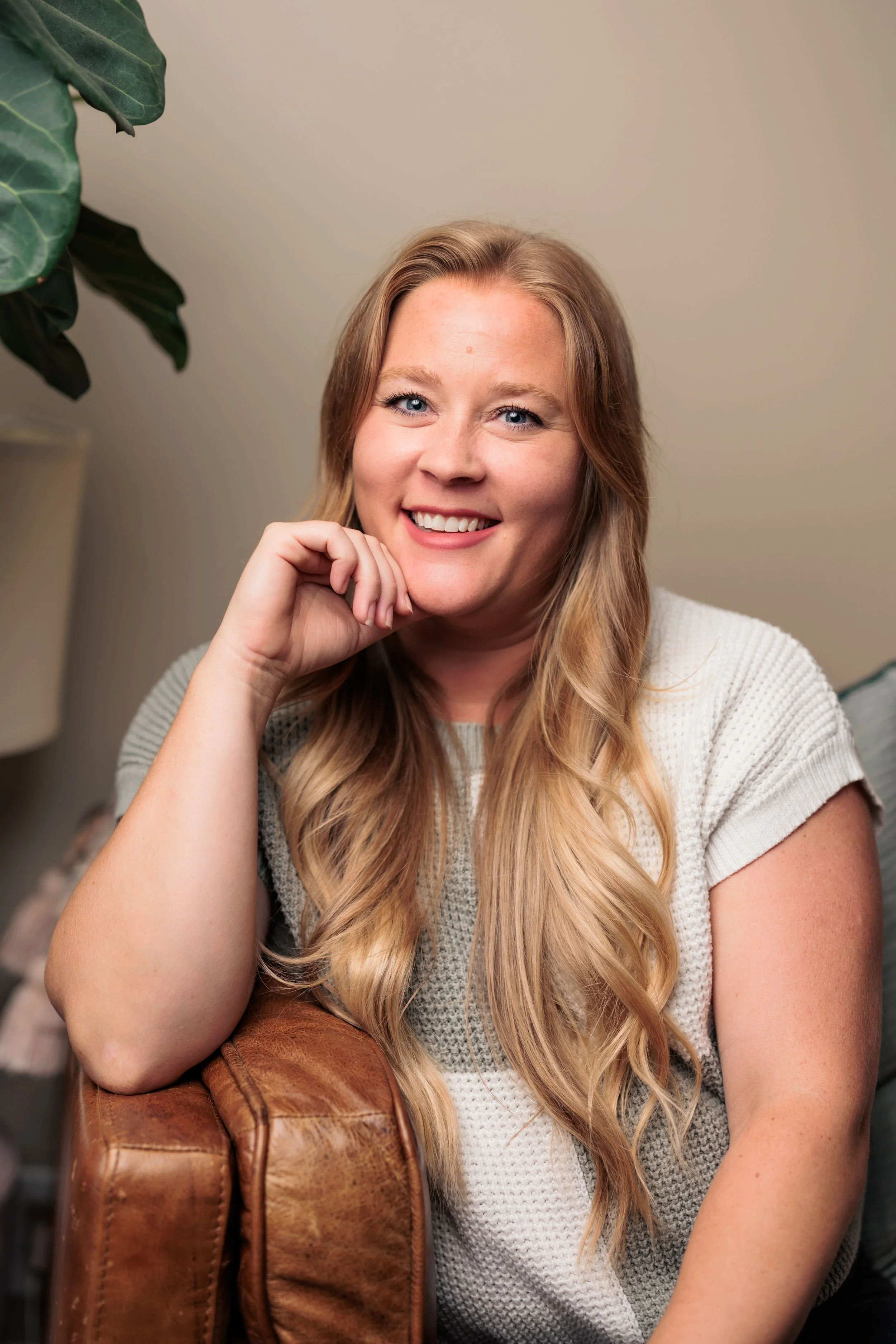 Kaylee Belt, LCSW, trauma therapist in Nashville, TN sitting and smiling in a warm, welcoming office setting.