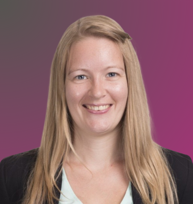 A woman with long blonde hair smiling, wearing a black blazer over a white top, with a purple background.