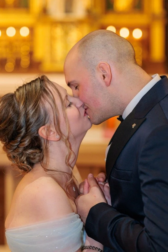 Eine Trauung in einer Kirche in  Warburg. Das Brautpaar steht vorm Altar und küsst sich.
