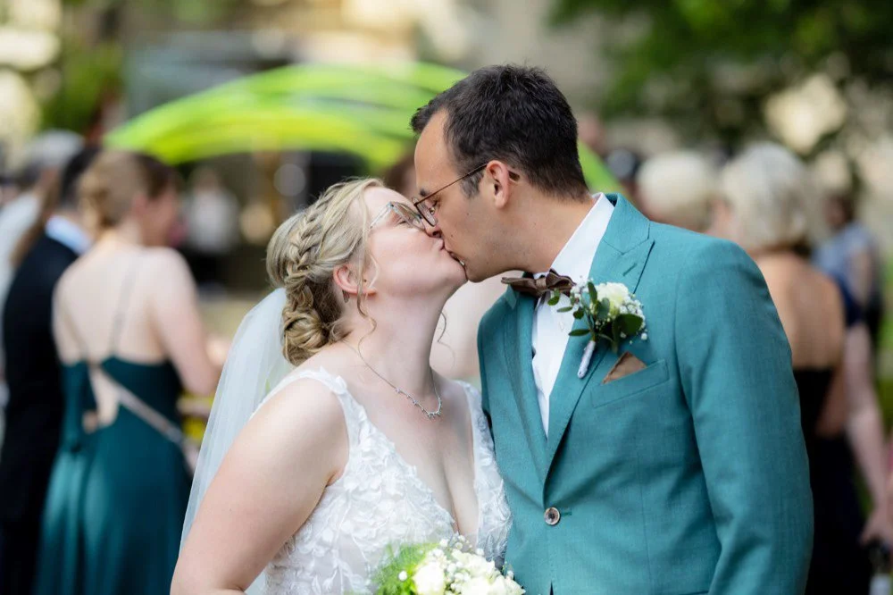 Nach dem Auszug aus der Kirche müssen das Brautpaar durch ein Feuerwehrspalier laufen und küssen sich danach