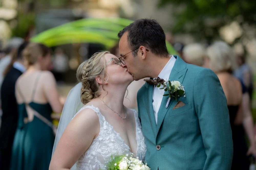 Brautpaar küsst sich nach dem es aus der Kirche ausgezogen ist.