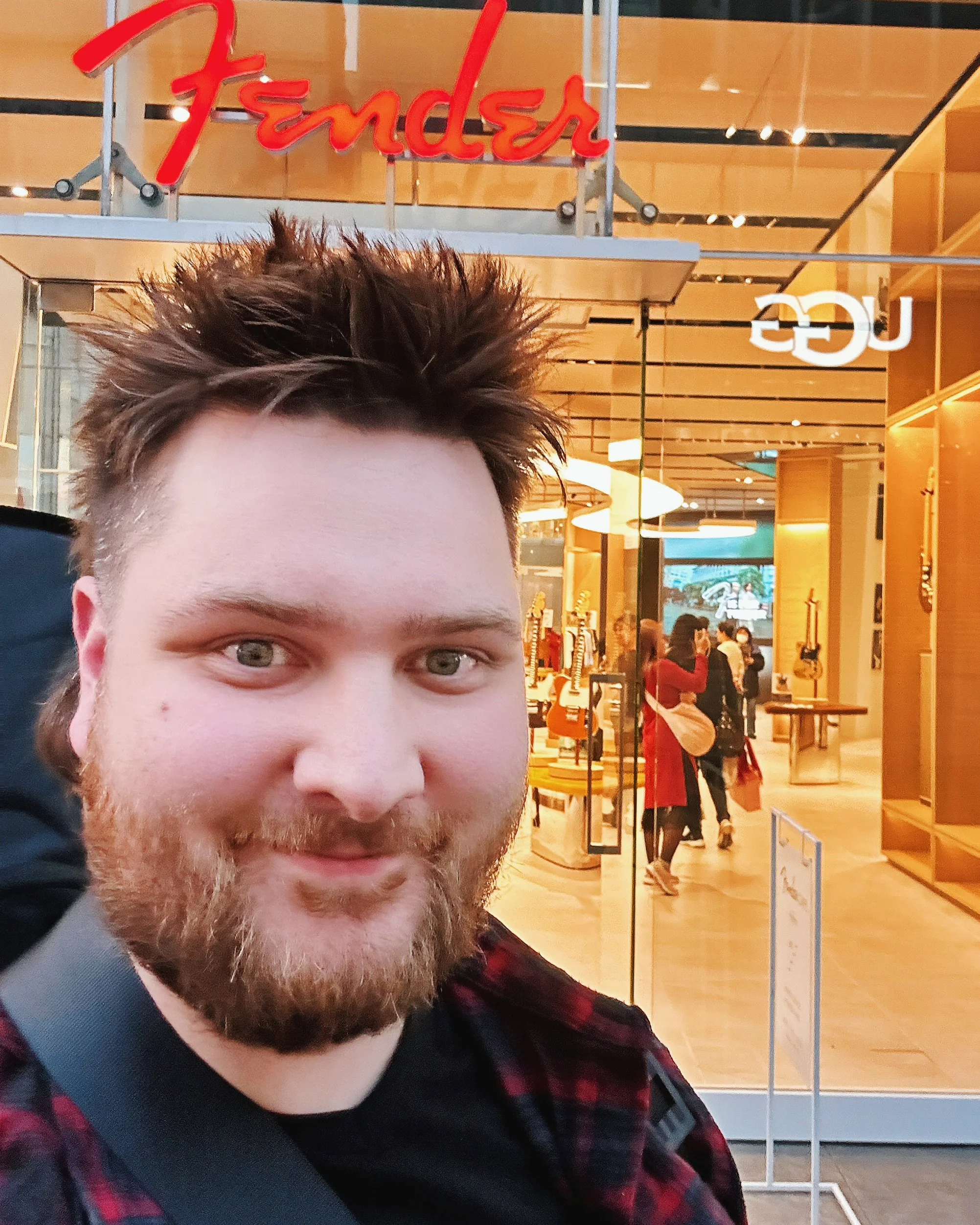 BS Creative co-founder, Brett Verlennich, taking a selfie outside the Fender Flagship store, with the store's interior and other people inside visible in the background.