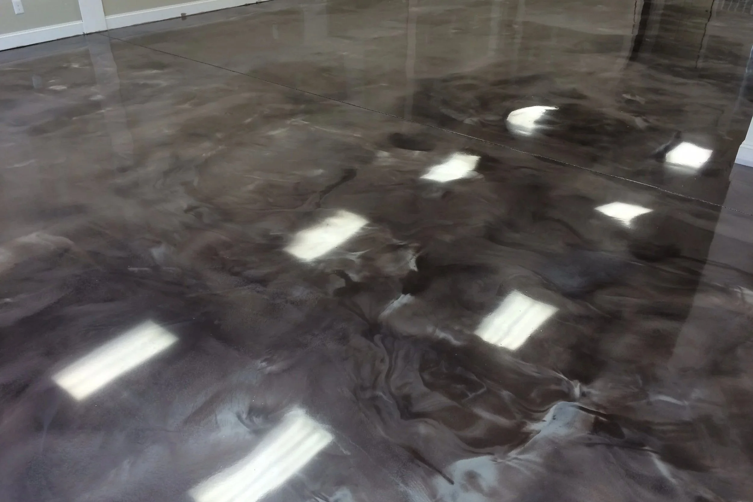 Smoke-gray metallic epoxy flooring with high-gloss movement and depth.