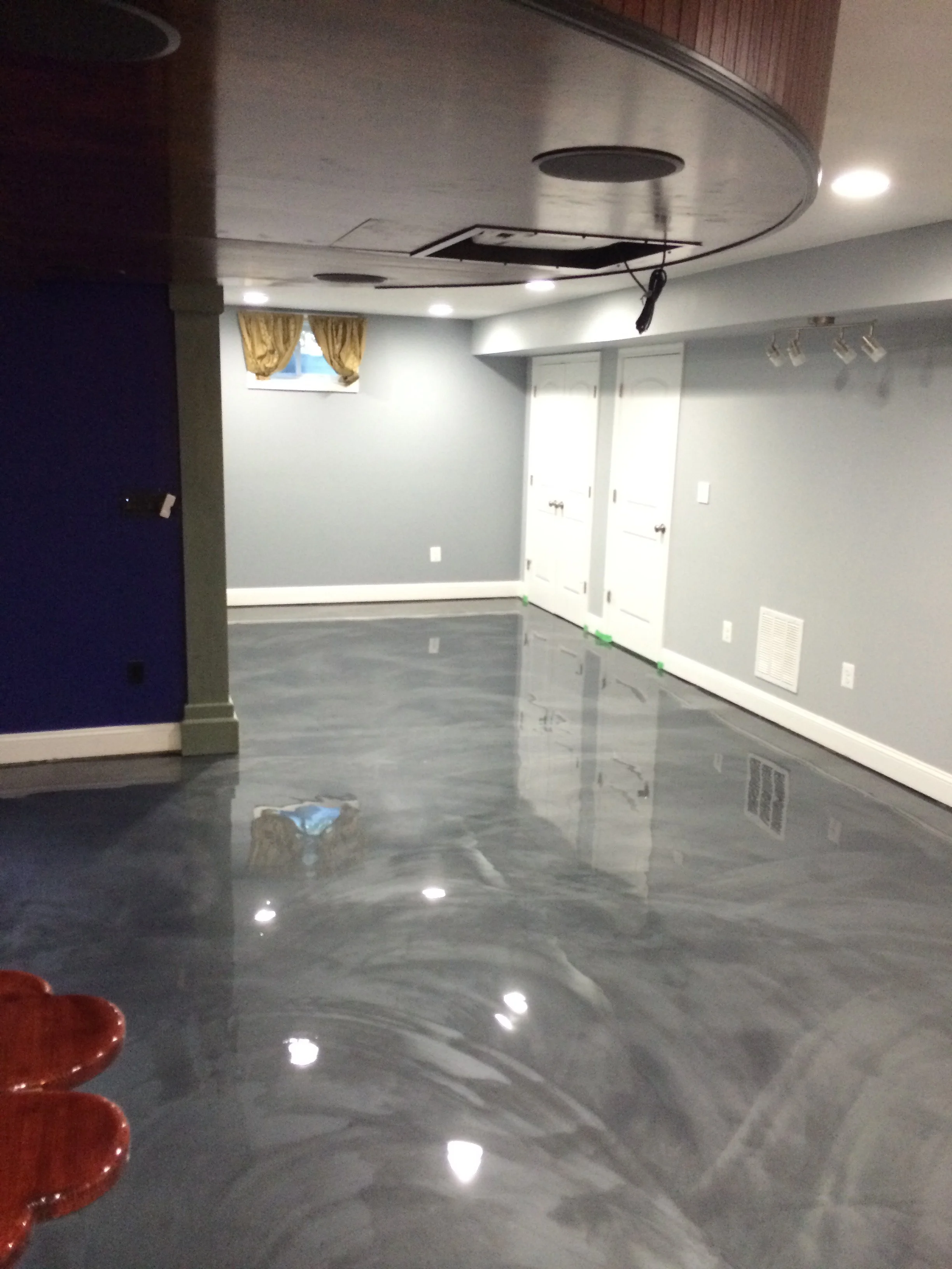 “Commercial epoxy floor installation featuring a smooth gray coating in a large workspace.”