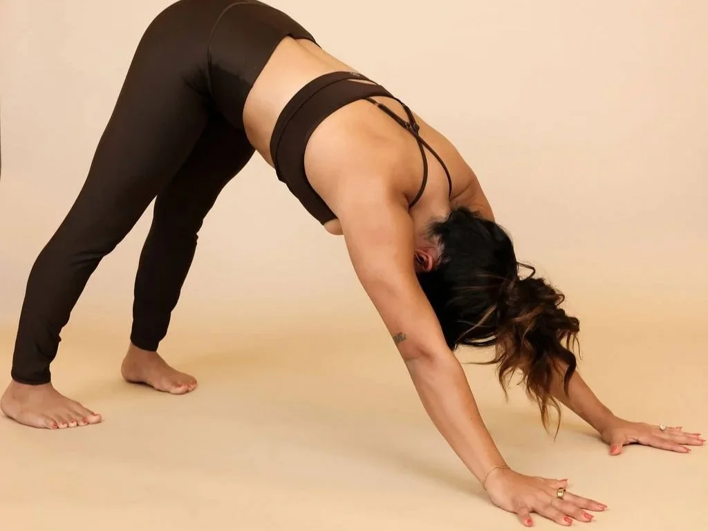 Woman in white workout clothes performing a yoga balance pose