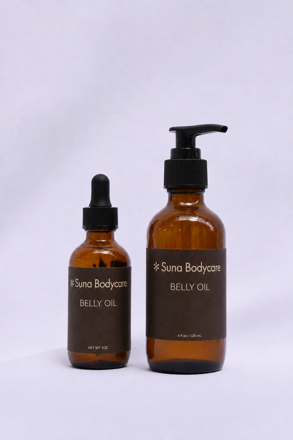 Two amber glass bottles of Suna Bodycare belly oil with black dropper caps on a white background.