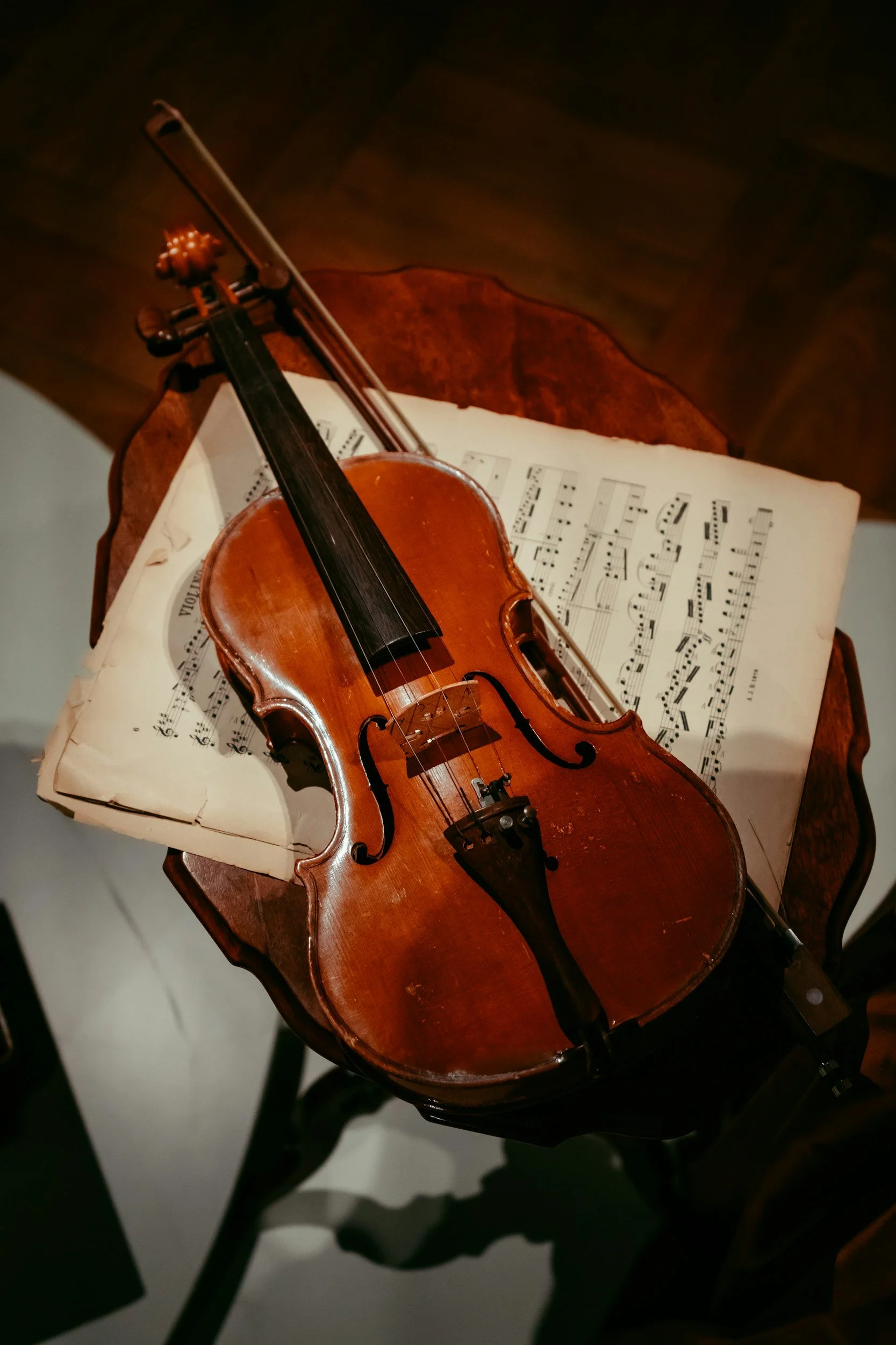 Un violín de madera sobre una partitura musical antigua en una mesa de madera