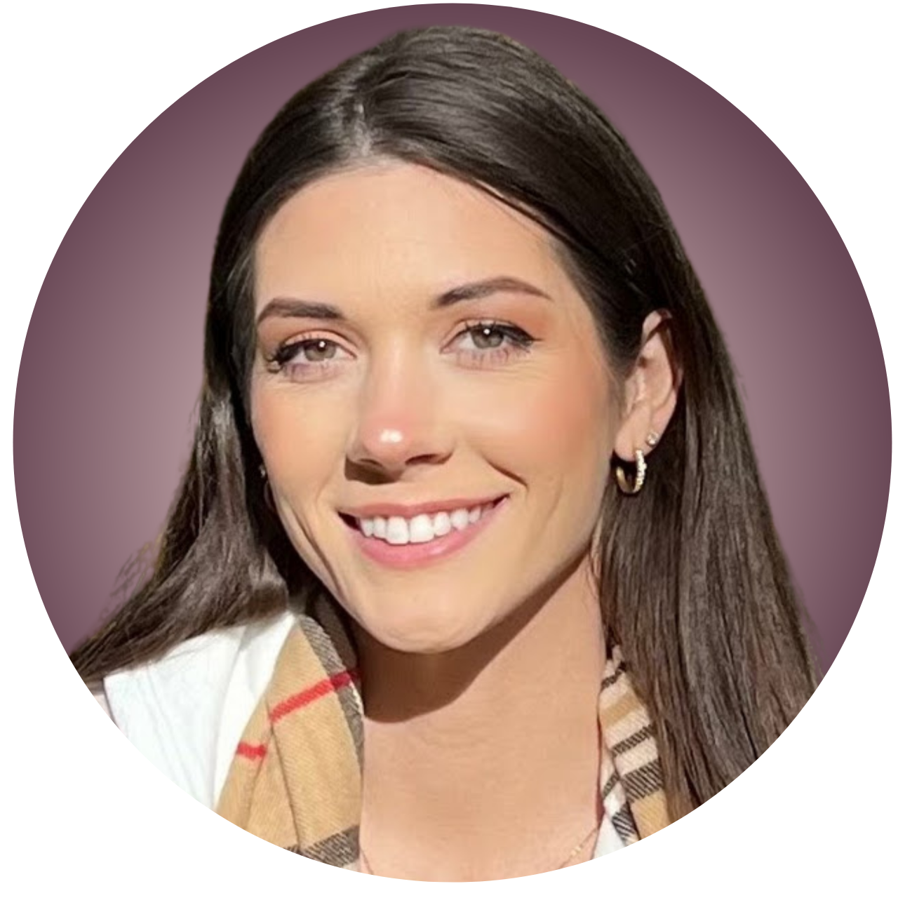 A woman with long brown hair and hoop earrings smiling, wearing a white shirt and a beige checkered scarf against a pinkish background.