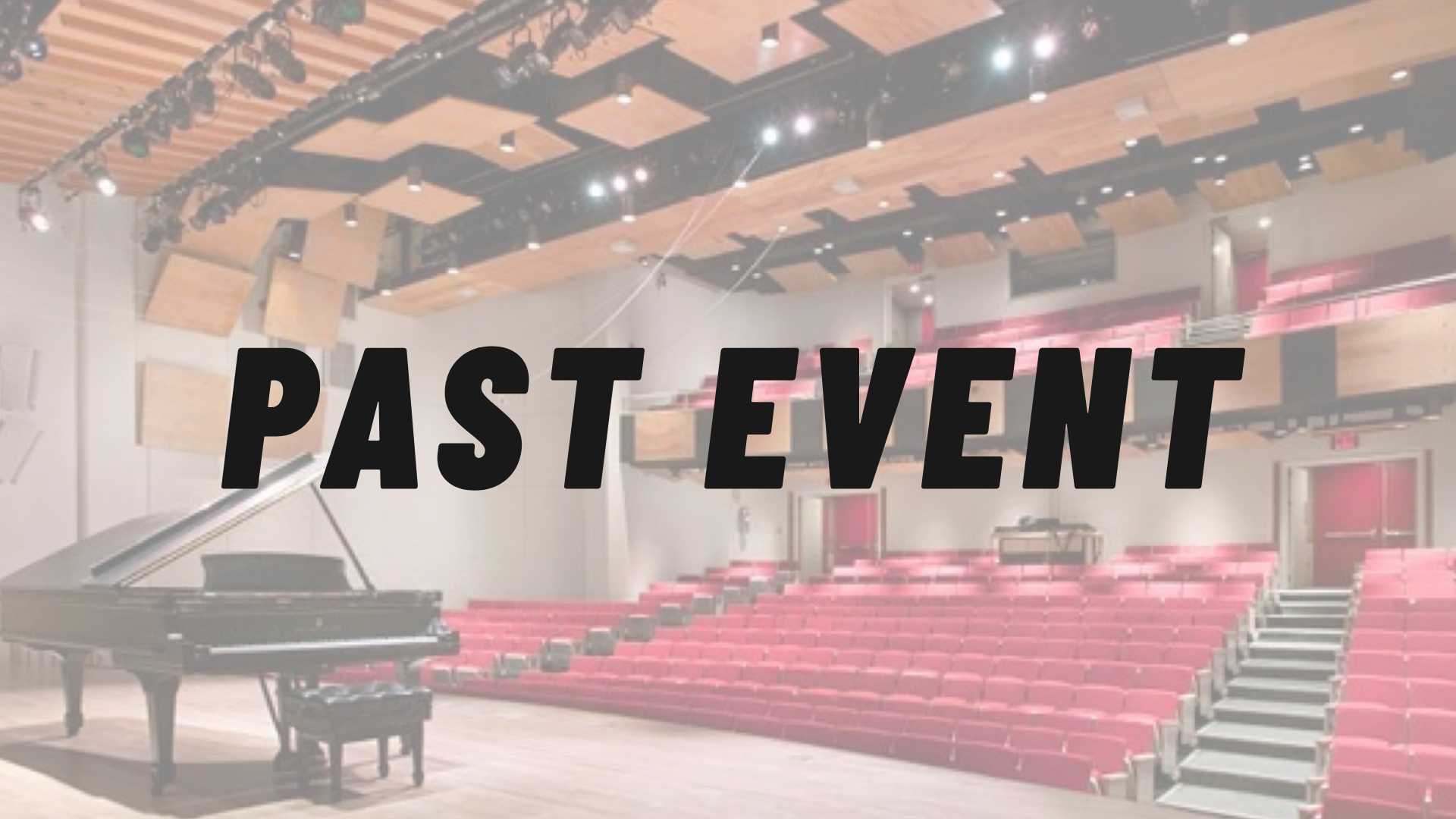 Empty auditorium with a stage and grand piano in the center