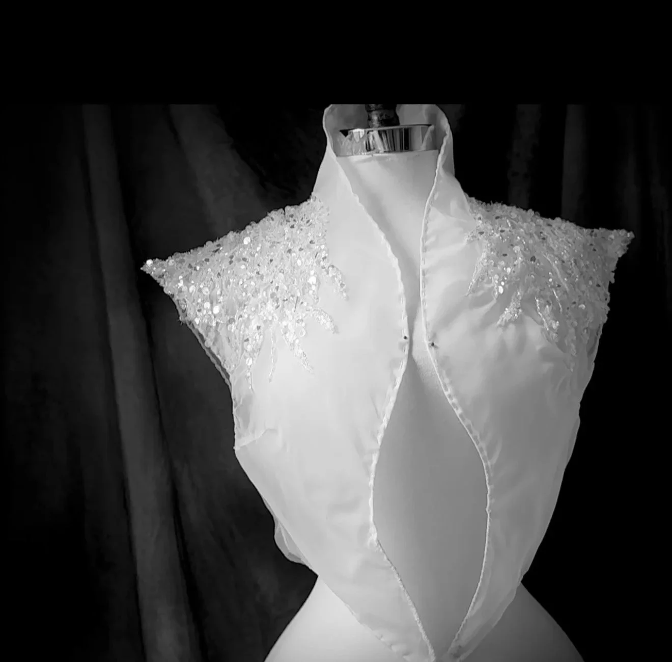 White sleeveless dress with sequined shoulder details on a mannequin