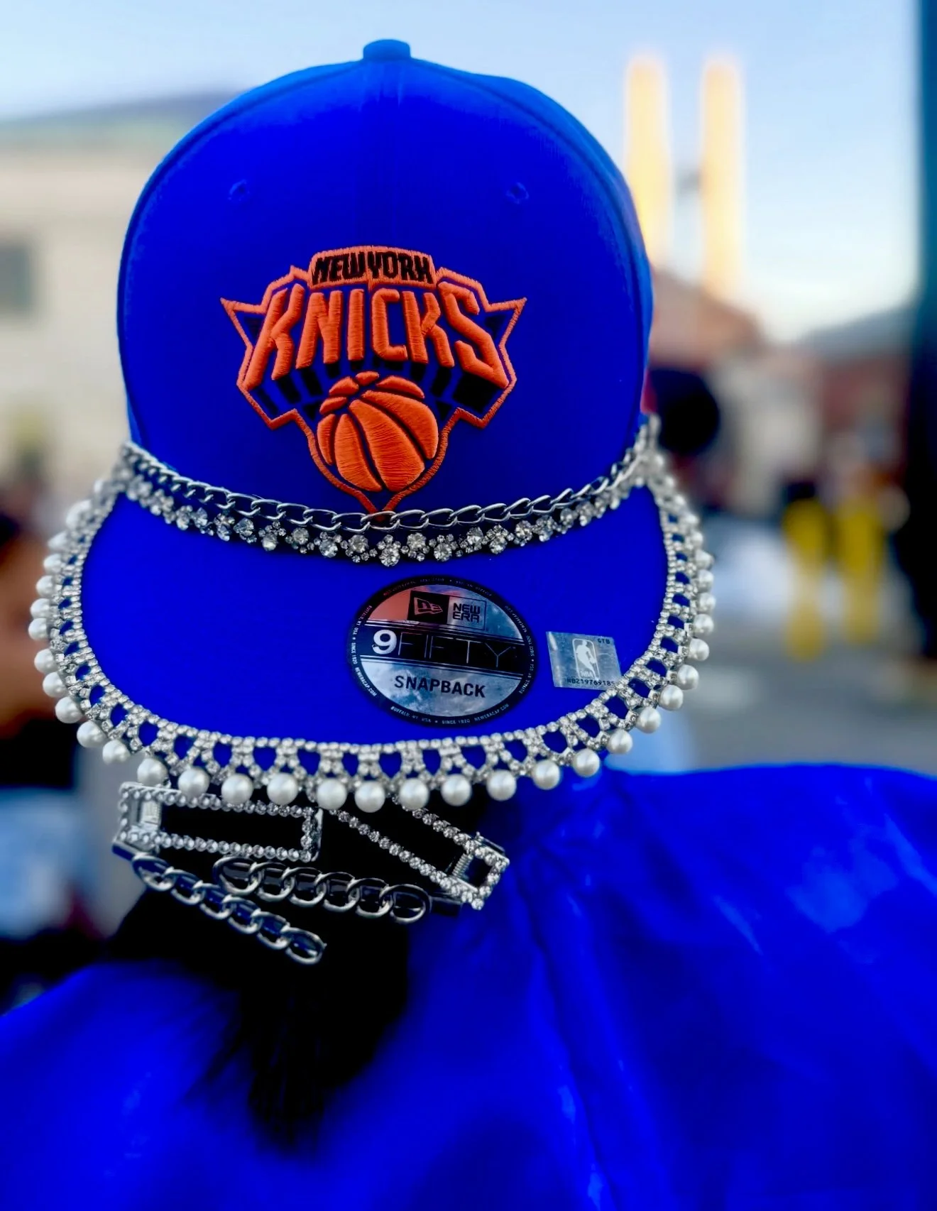 Blue New York Knicks baseball cap decorated with rhinestones and pearl chains, back view.