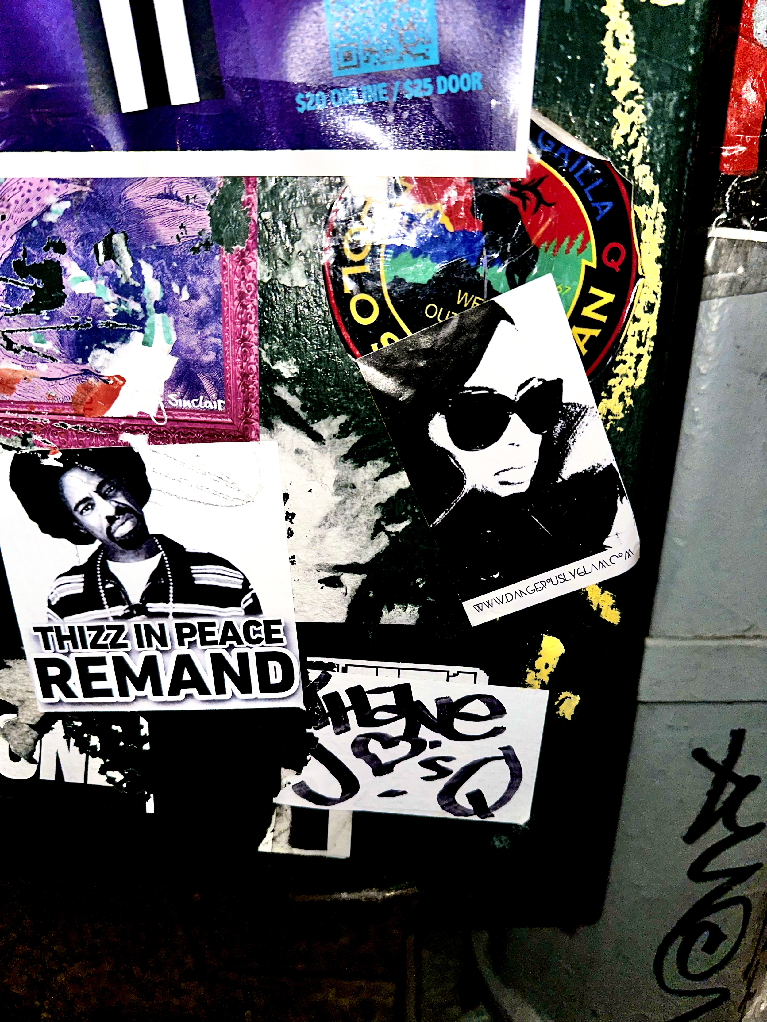 Close-up of a collage of stickers on a surface, including a black and white photo of a woman with sunglasses, a sticker with the text 'Thizz in Peace REMAND' featuring an image of a woman, and other colorful and graphic stickers.