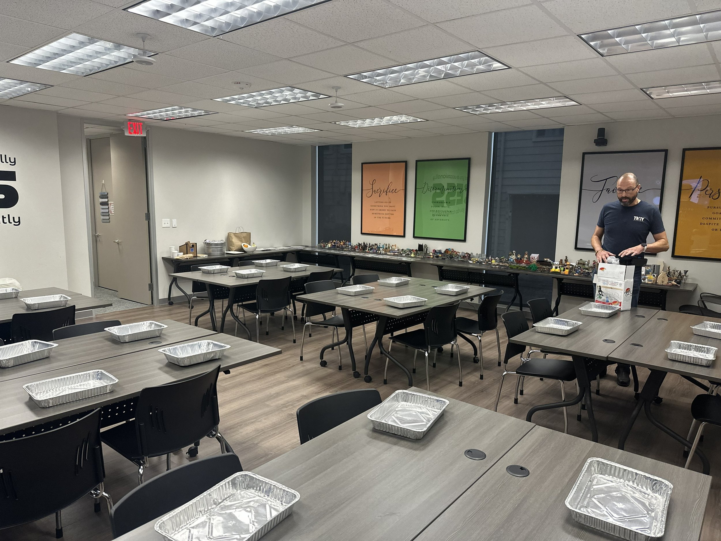 A classroom with tables, chairs, and colorful wall posters.
