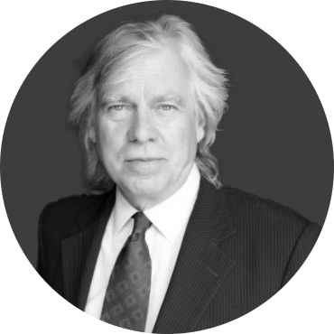 Black and white portrait of a man with shoulder-length hair wearing a suit and tie.