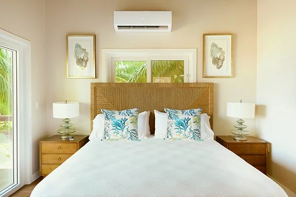 Bedroom with a large bed, wooden headboard, two bedside tables with lamps, and framed artwork on the wall.
