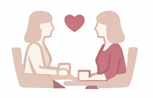 Two women sitting at a table with a heart symbol above them, engaging in conversation.
