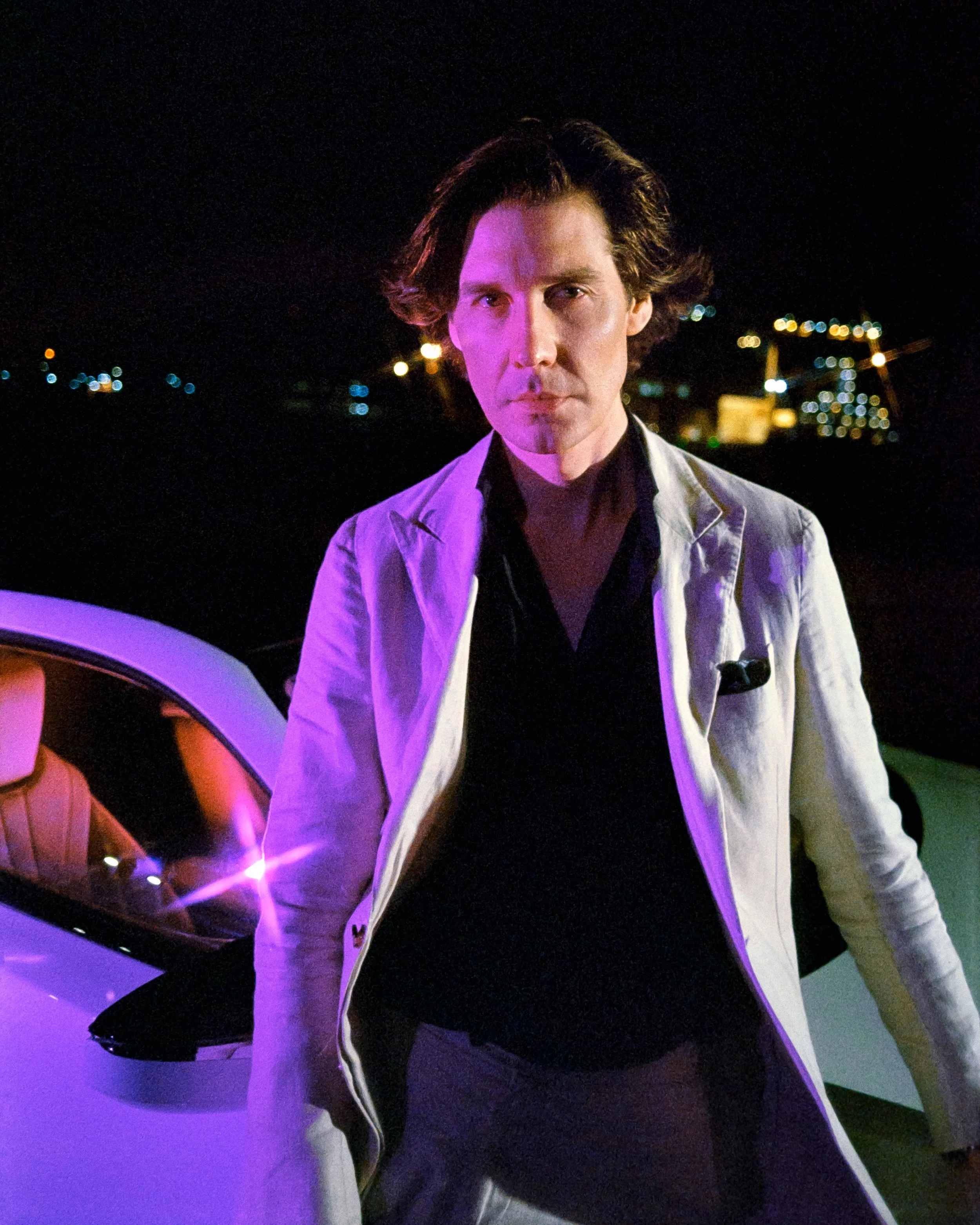 Clem Kennedy standing in front of his Lexus, glowing purple lights on half his face, in a 'Miami Vice' themed photoshoot, on 35mm Film - Portra 800