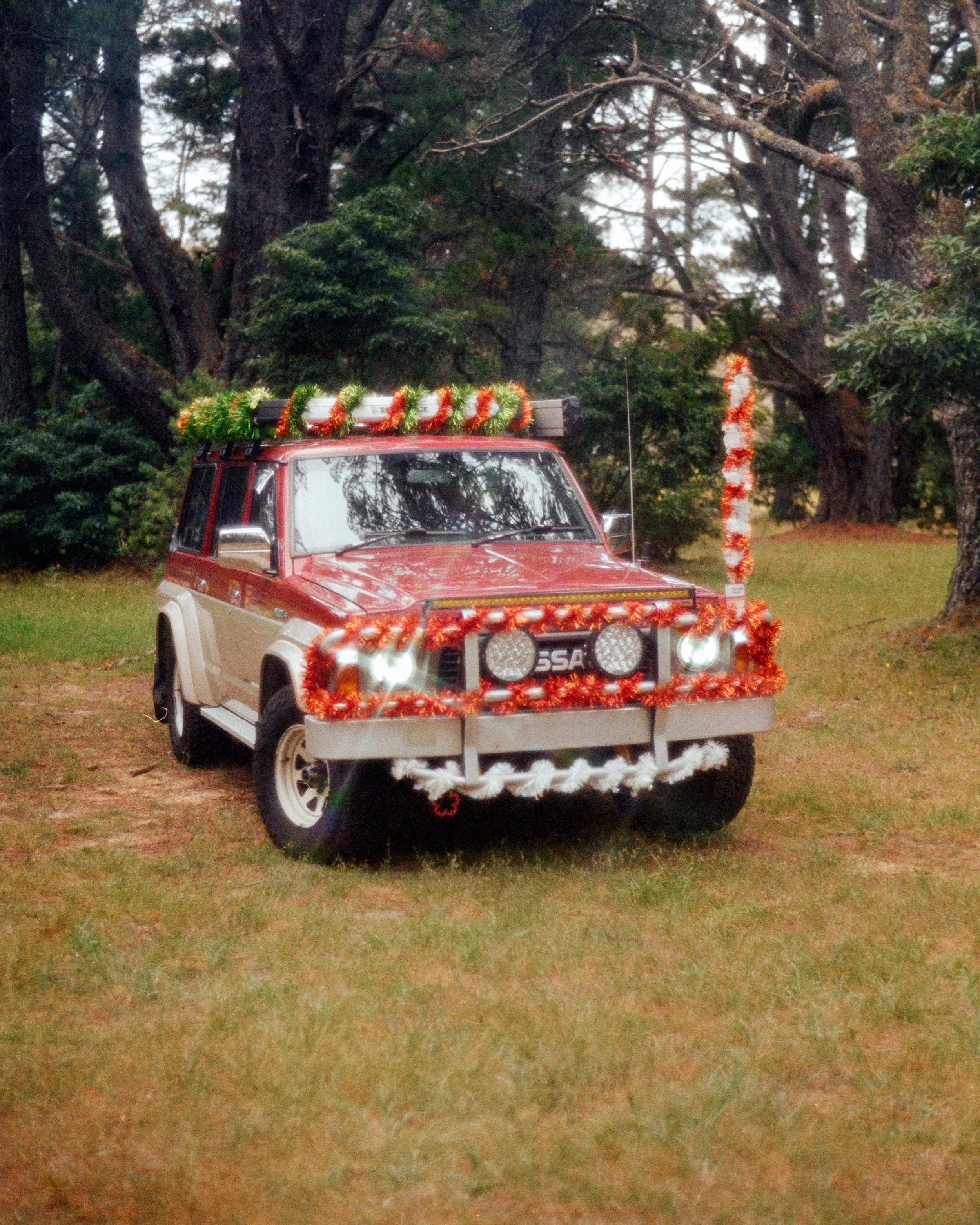 Scorpion, Josie's GQ Patrol wrapped in tinsel, in the forest, shimmering under the sun, shot on 35mm Film - Kodak Gold